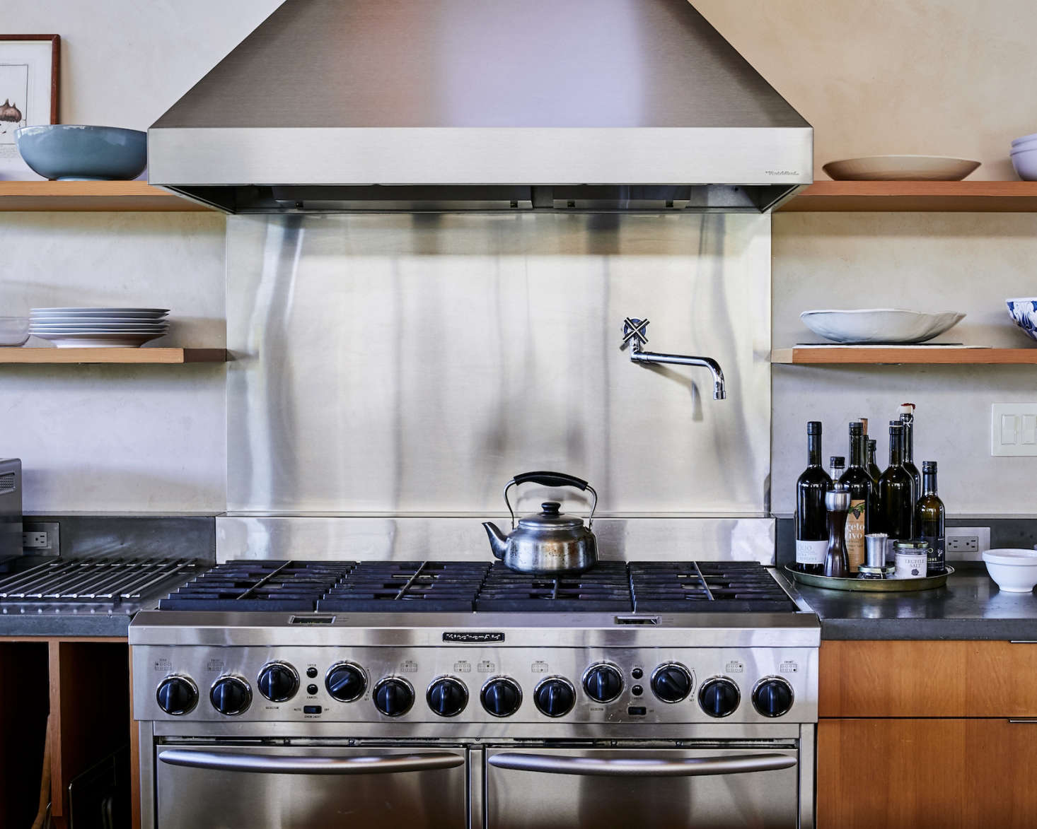 The backsplash of the oversize gas range is stainless steel, as are all the appliances (the material was chosen for its durability, said architect Anding). A Sori Yanagi Tea Kettle is perched on the stove (it