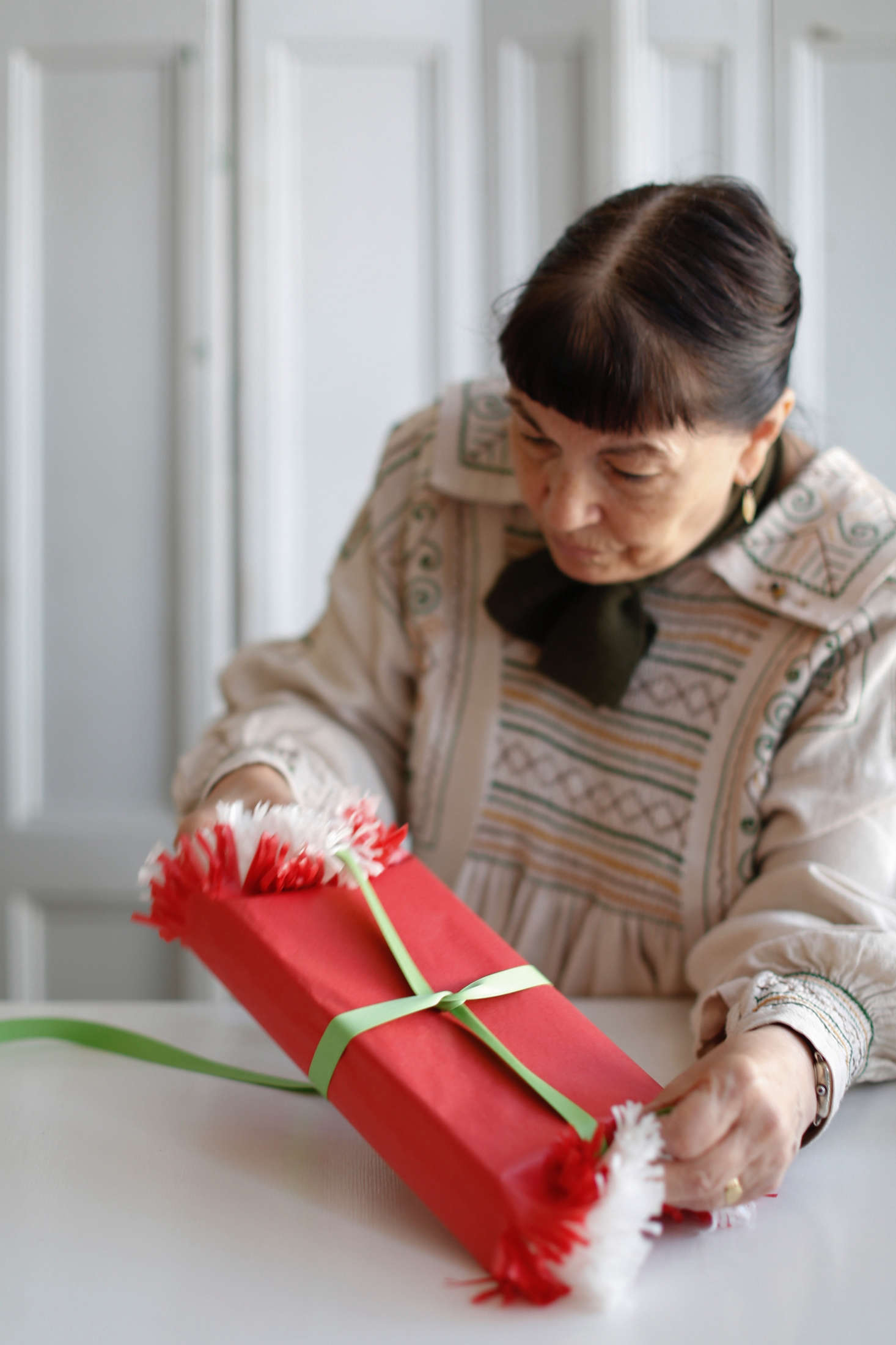 Step 3: Wrap a single, long piece of ribbon around the gift, starting with the closed edges and ending with the fringed sides. Wrap the ribbon right over the fringed ends, securing the open ends with the ribbon.