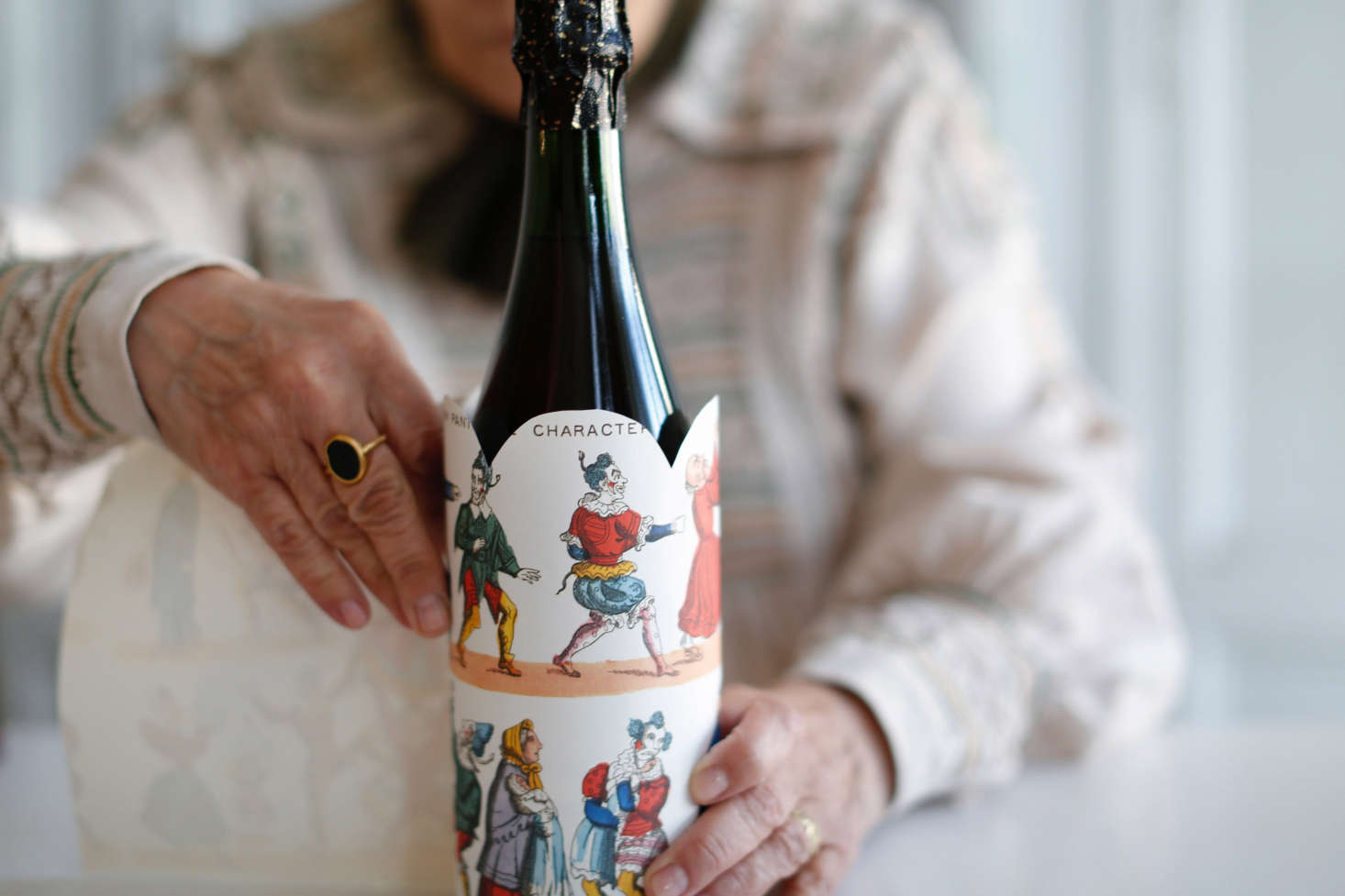 Step 3: Cut the decorative paper into a strip about 7 to 8 inches wide and long enough to wrap around the circumference of the bottle. (Bottles vary in shape and size, so gauge accordingly.) Then, cut the top edge in a scallop shape.