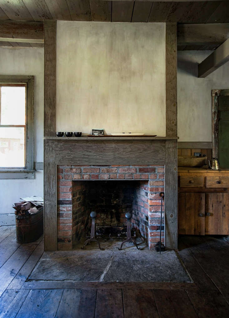 Separating the kitchen from the dining area, a central fireplace looks original but was actually added by Don and Ray.