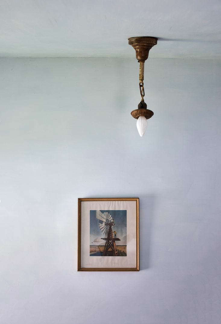 A vintage print complements an original farmhouse light fixture.