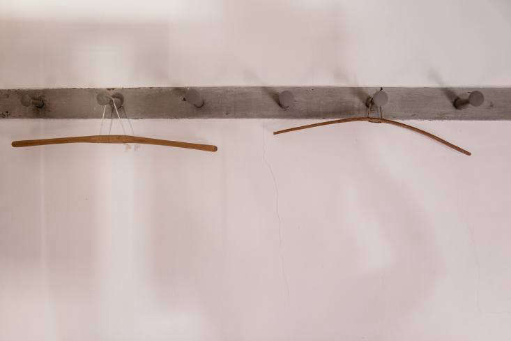 simple bentwood and string clothes hangers hang from a stretch of peg rail, a q 42