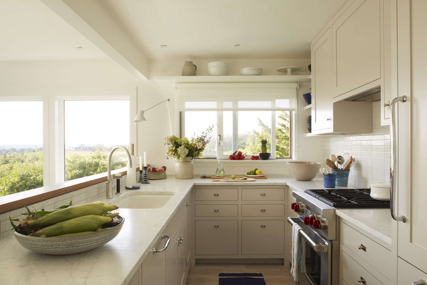 The kitchen, which overlooks the living room, kept its previous footprint but otherwise received a complete overhaul with Carrara marble countertops, a backsplash of textured white tile from Ann Sacks, and locally made Shaker-style cabinetry with Swedish hardware.
