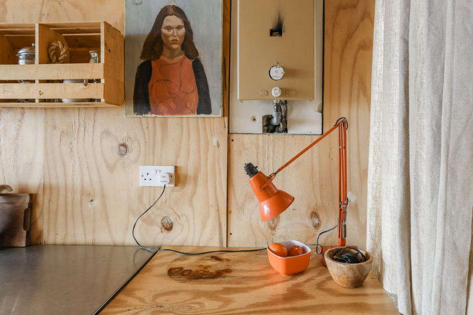 The hut is mostly plywood, but Maria and Durrell incorporate a playful palette of orange, red, and green when they can. Photograph by Marcia Mihotich from Two London Creatives Shore Up a Tiny Beach House, Ikea Hack Kitchen Included.