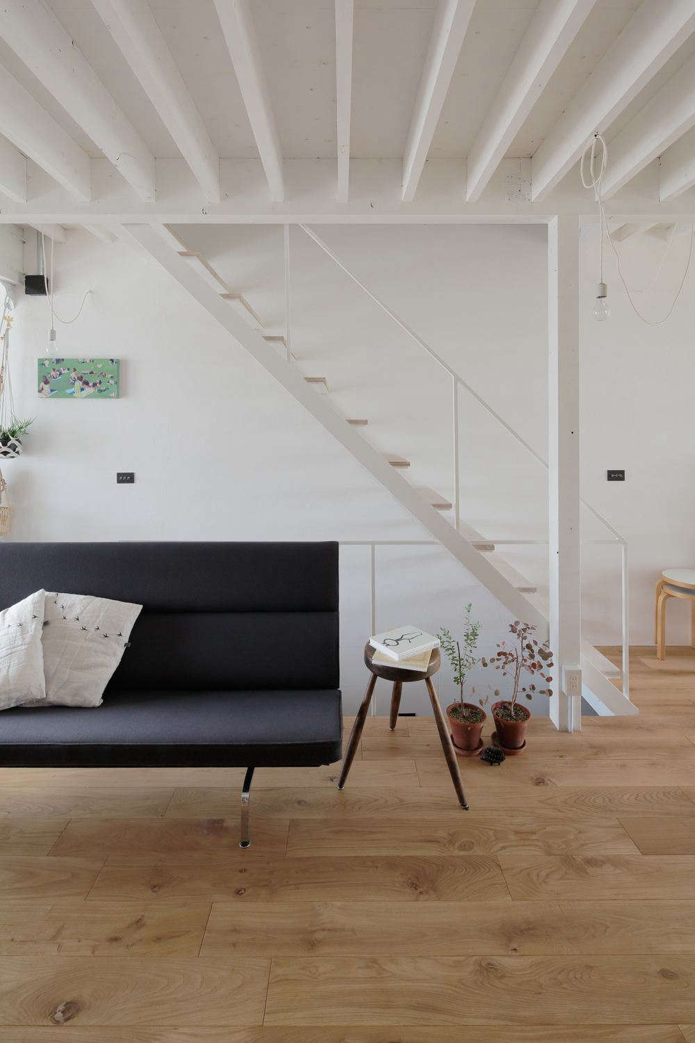 The ceiling beams and wooden stair treads play off each other in a rhythmic pattern. 