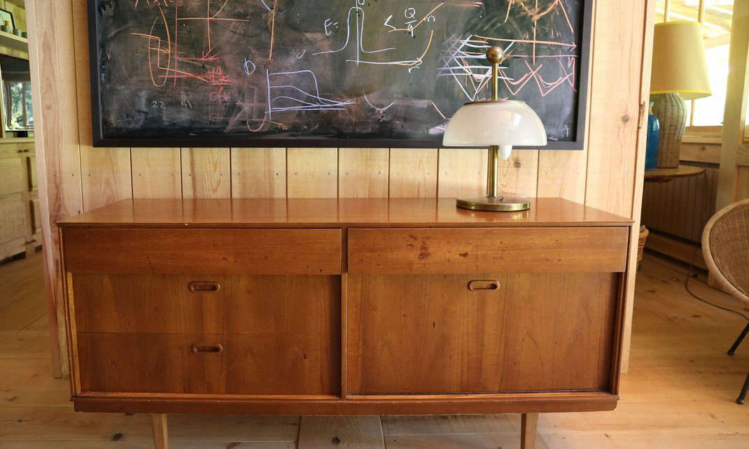 A midcentury credenza is topped by a vintage lamp.