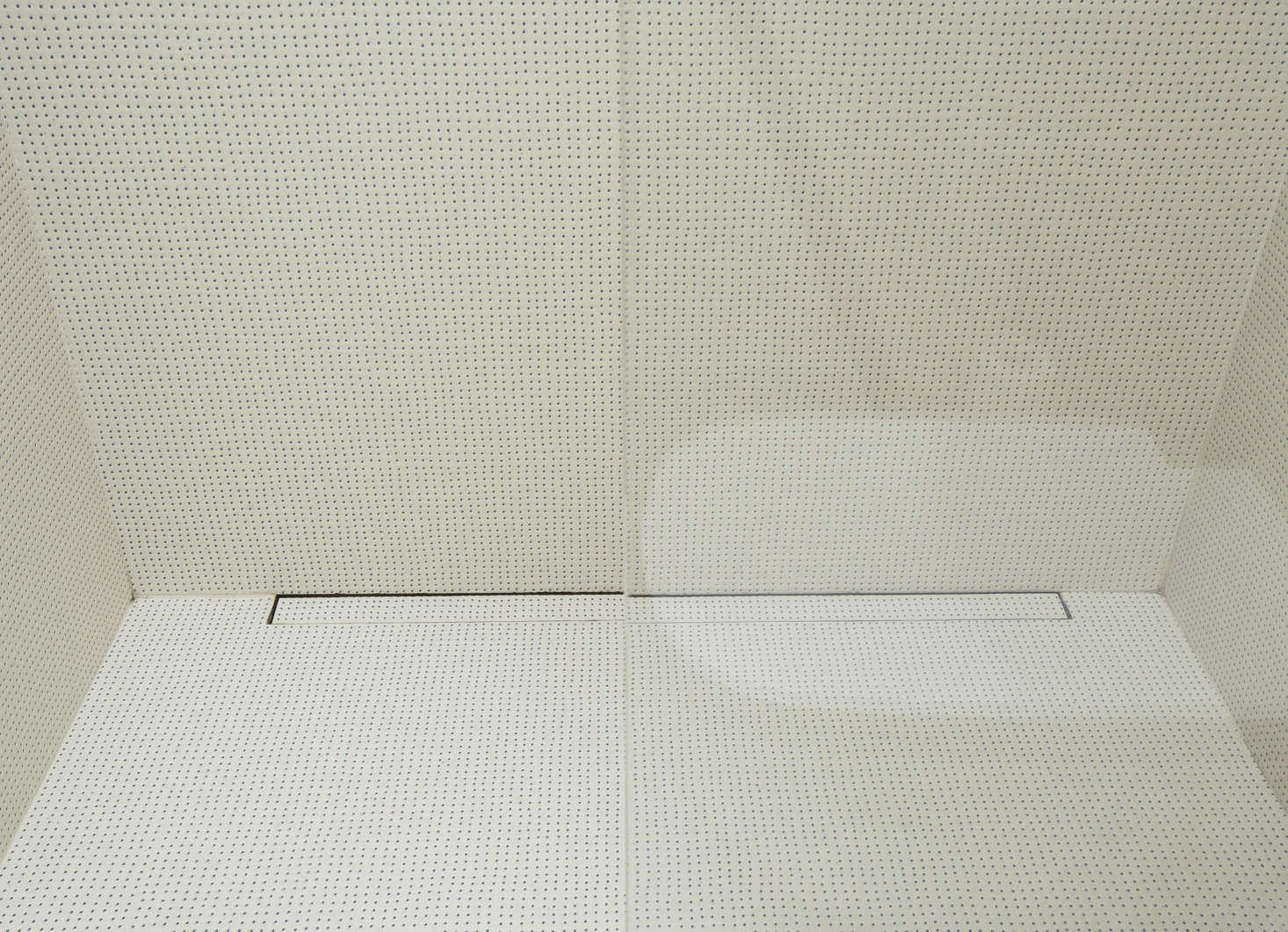 The tiles on the bathroom floor and shower walls are the ceramic Pico Tiles by Ronan & Erwan Bouroullec for Mutina in Blue Dots Blanc. The drain is an ordinary linear shower drain with a tile insert.