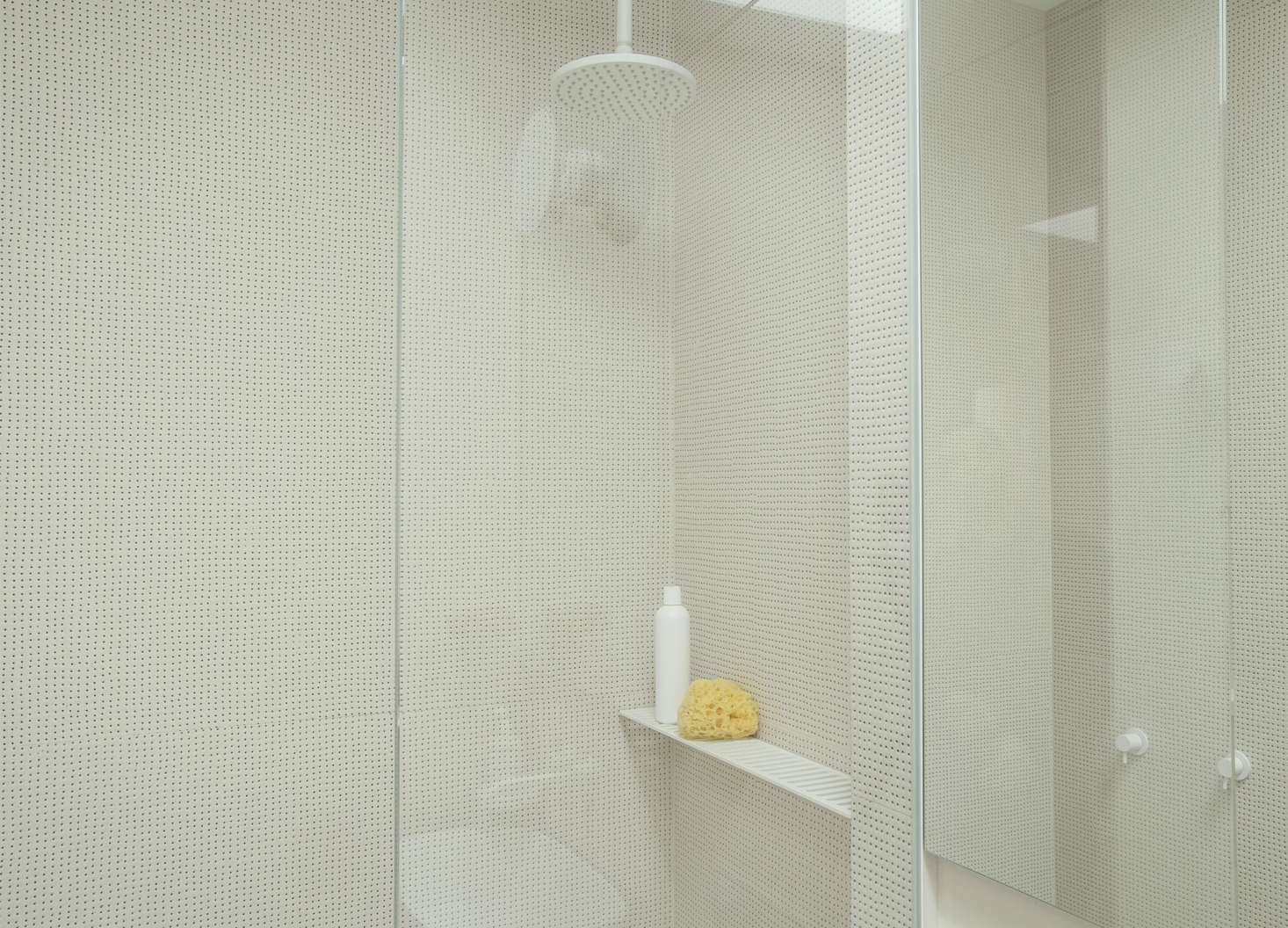 Wall tiles with a pin-size blue dot give the bathroom shower a perforated look. Photograph by Matthew Williams for Remodelista; styling by Alexa Hotz.