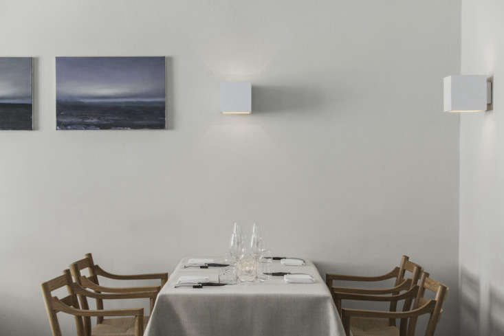 in the dining room, some tables are draped with plain tablecloths while others  19