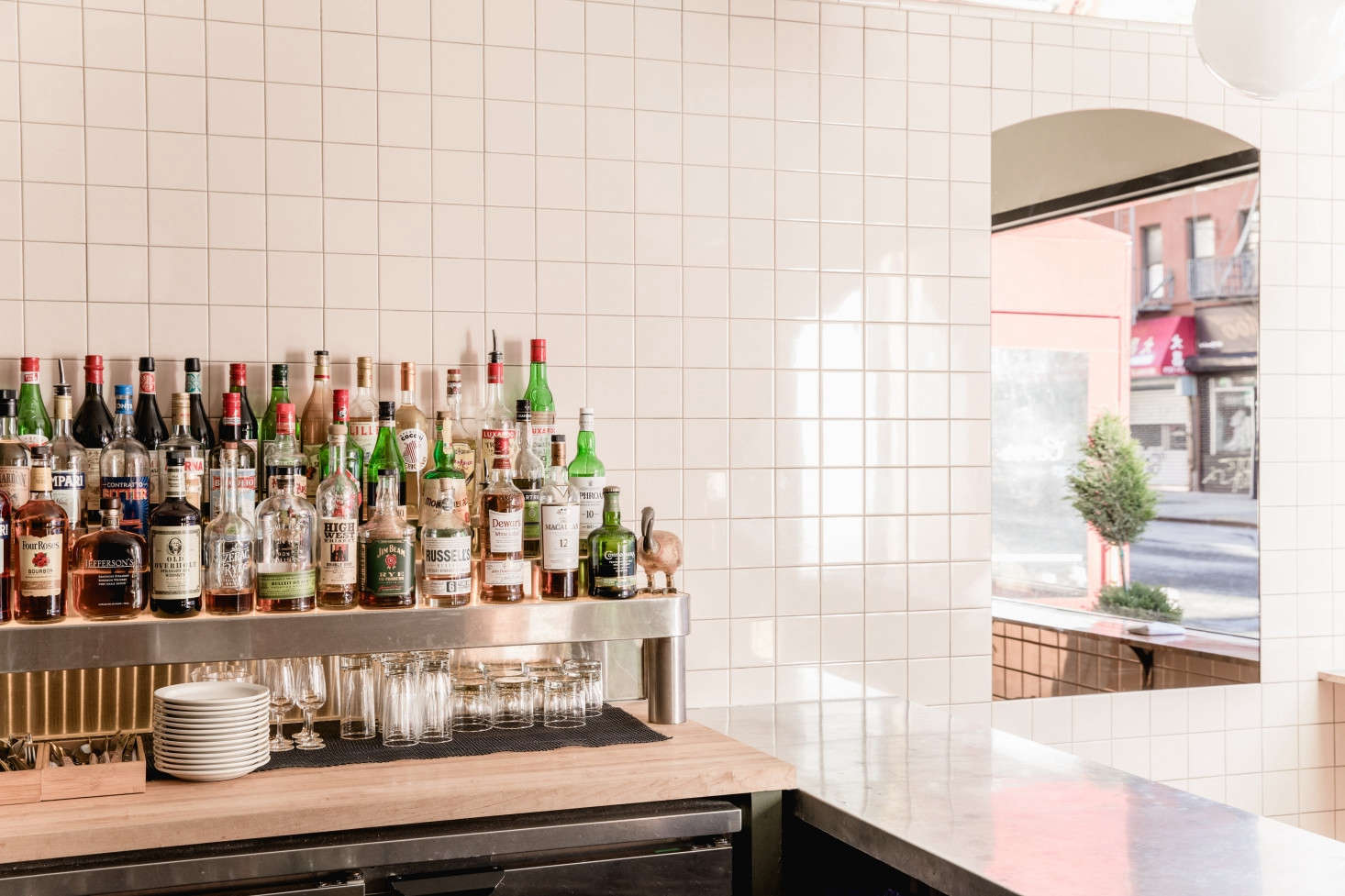The custom, curved zinc bar is the center of the space (and all of the cooking takes place behind it). The owners also had a three-level liquor shelf custom-built by a metal shop in Williamsburg. 