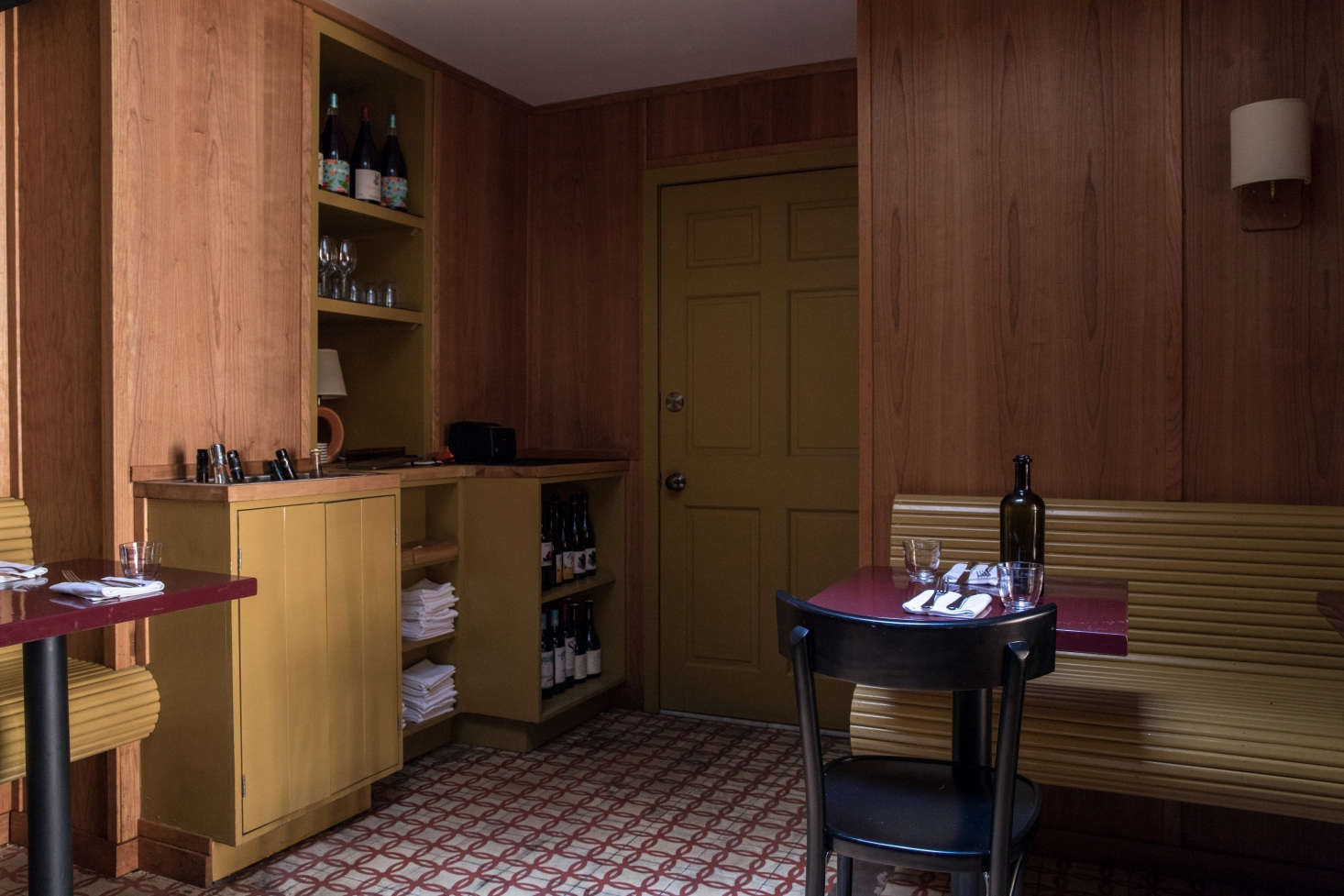 In the small back room, a wall of built-ins is both artful and efficient. The benches, cabinets and shelves, and door (which leads to the small bathroom) are all painted in Benjamin Moore