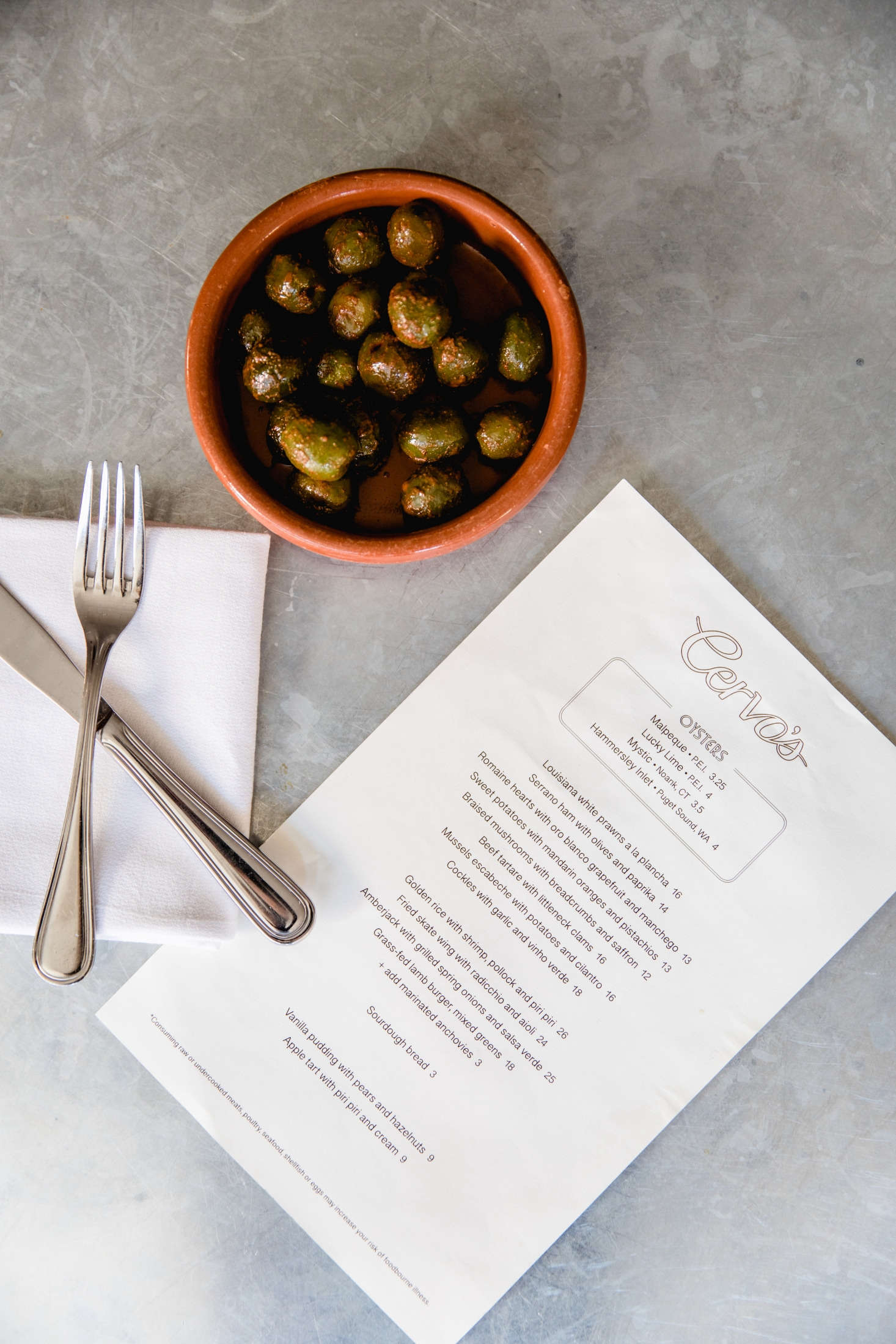The restaurant serves small dishes—like warm olives with lemon zest—in terracotta dishes called cazuelas from Spain, imported from Despaña.