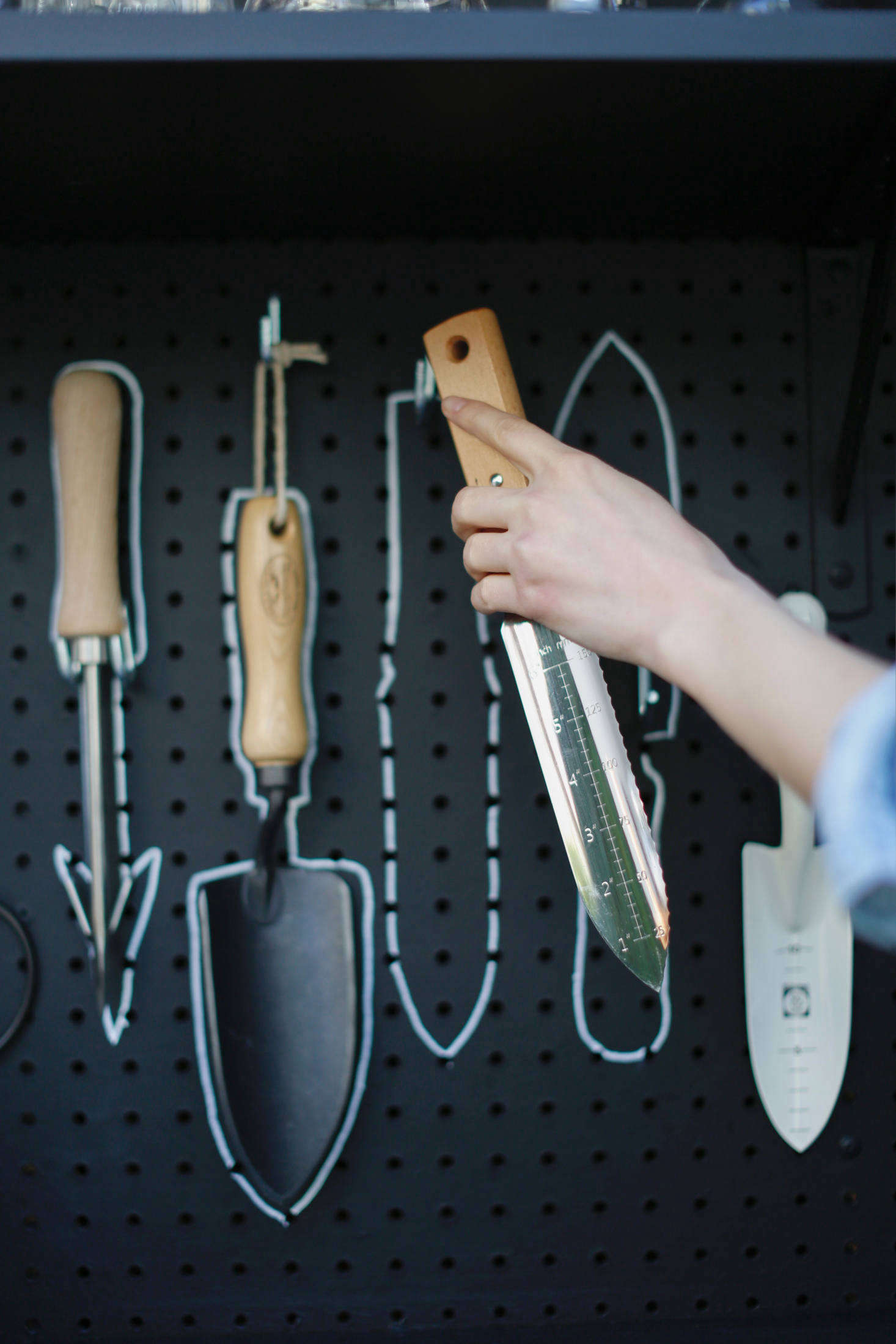 A Hori Hori Knife gets put in its place. Should Michelle buy new gardening tools or decide to rearrange them, the outlines can be wiped off and redrawn.