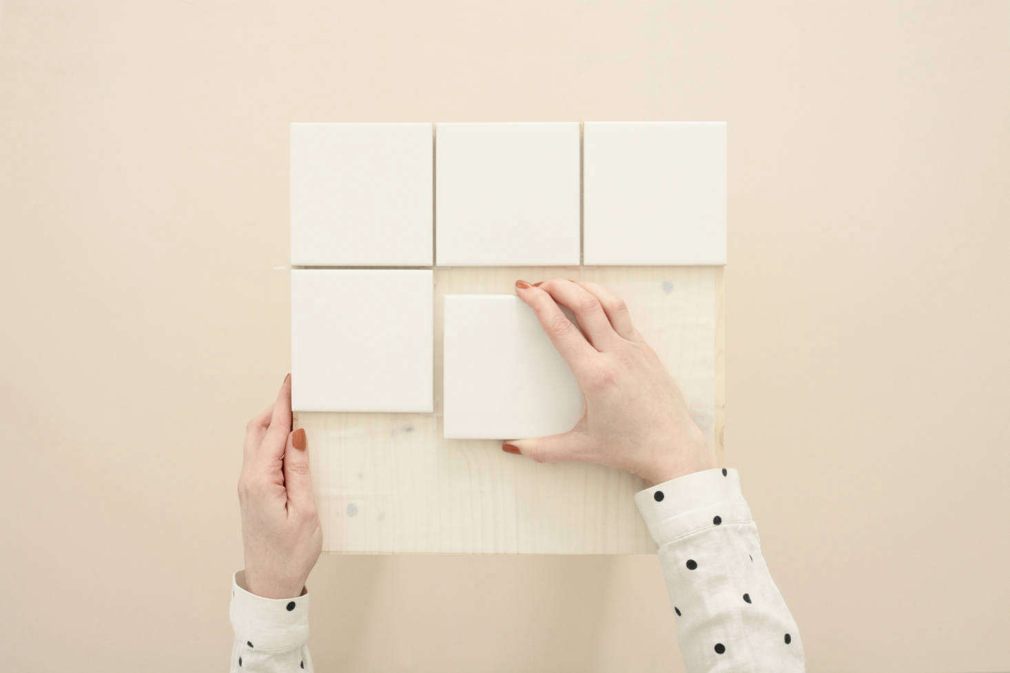 Standard 4-inch Square Ceramic Wall Tiles are $8.36 per square foot at Home Depot. Place the first one in a corner and carefully space so that the gaps between tiles are even.