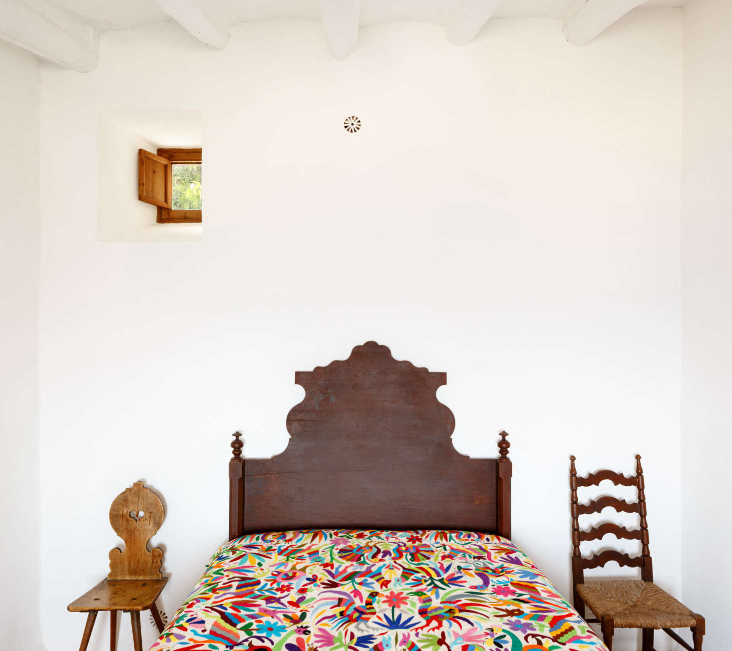The architects added small windows in the back of the house for cross-ventilation. The small floral vent above the bed is a crucial addition: 