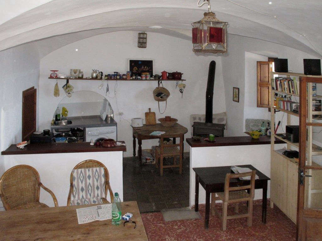 The kitchen and dining room were dark and cluttered, with a half wall that divided the space.