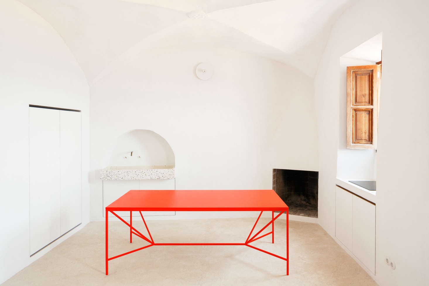 In the streamlined kitchen, nearly everything is concealed within the walls and windowsills. In one corner, the architects uncovered the original fireplace.