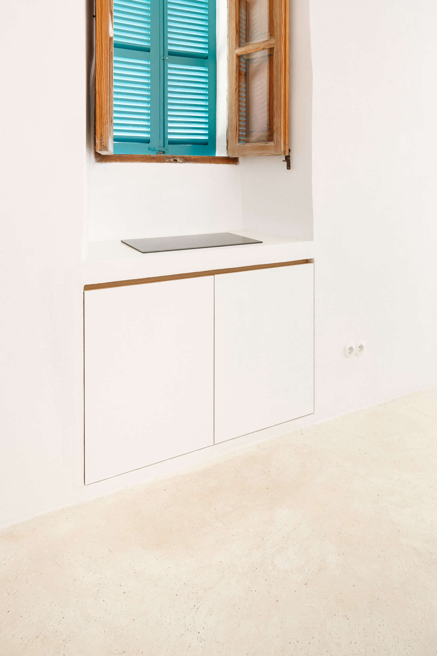 Beneath the cooktop, two more cabinets keep kitchenware out of sight.