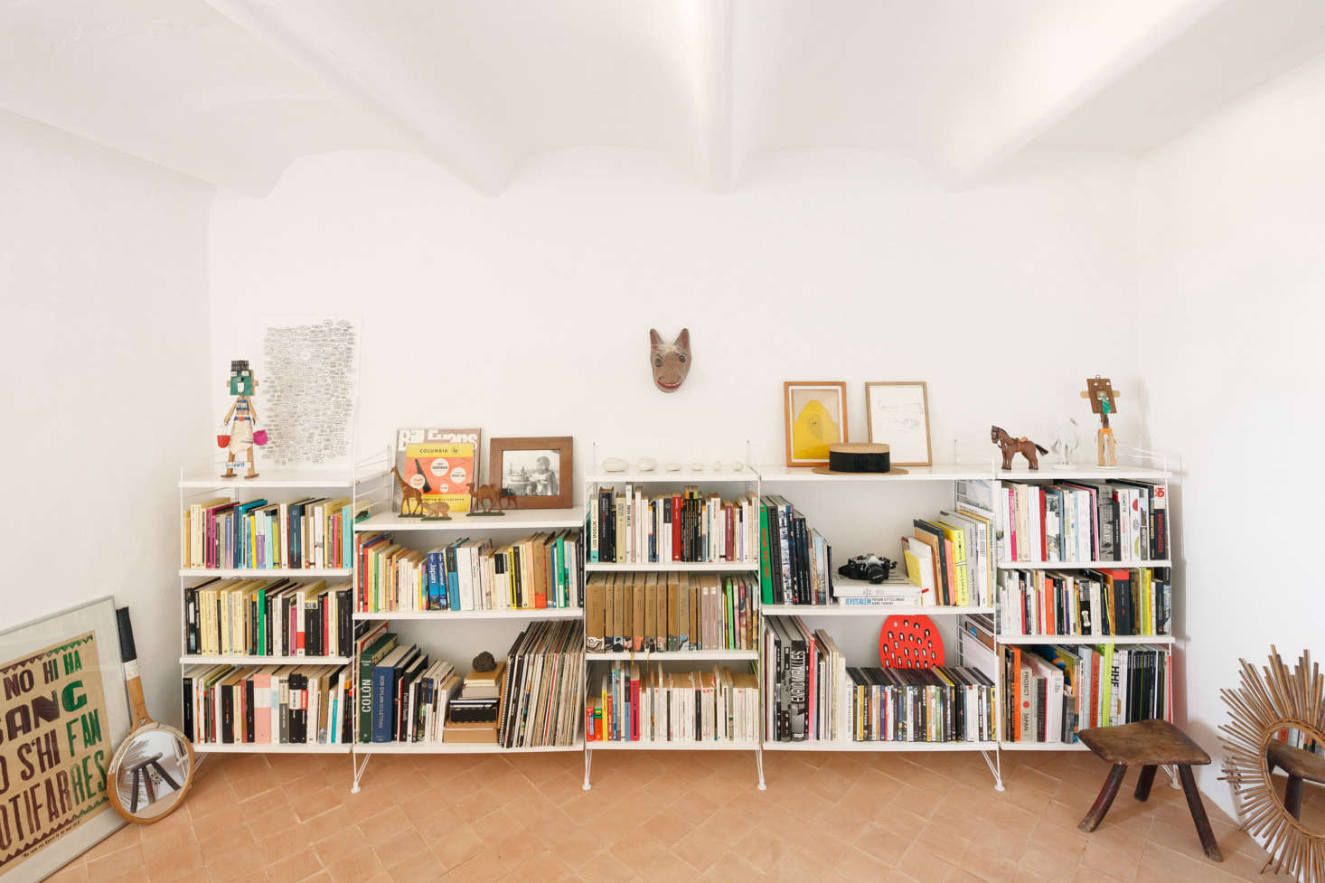 The library has the most lived-in look, with books and finds stashed on low white shelves. Palencia and Colón replaced the existing colored cement tiles with handmade terracotta square tiles 