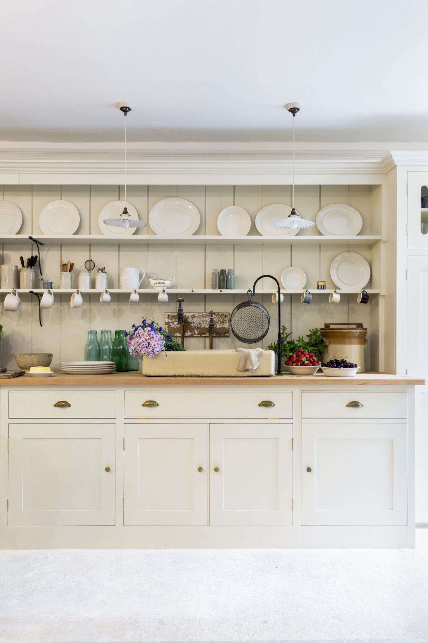 A Howe signature touch: the antique stoneware sink and reclaimed taps. (The thin black spout came from a school science lab and supplies distilled drinking water.) The counter is pitch pine that was cut from old church beams. A dishwasher is concealed to the right of the sink.