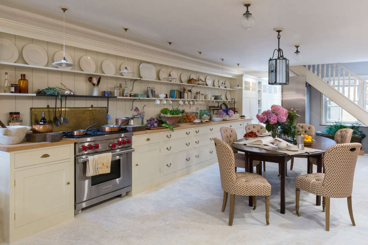 Another surprise detail: A large freestanding Sub-Zero fridge stands under stairs. At the far end of the space, the storage cabinets extend to a small pantry with a butler