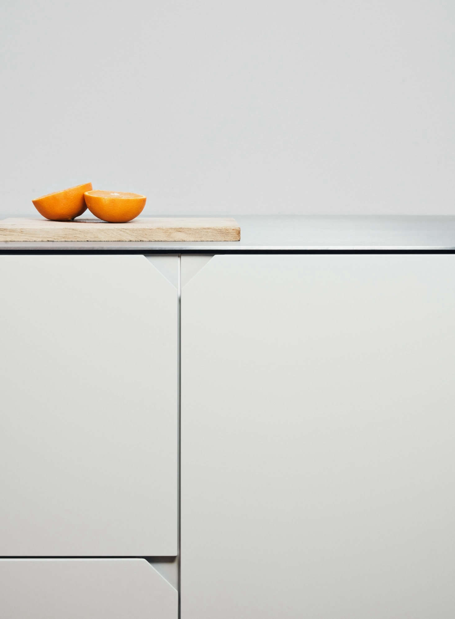 The triangular edge pulls neatly finish the horizontal and vertical lines of the cabinets.