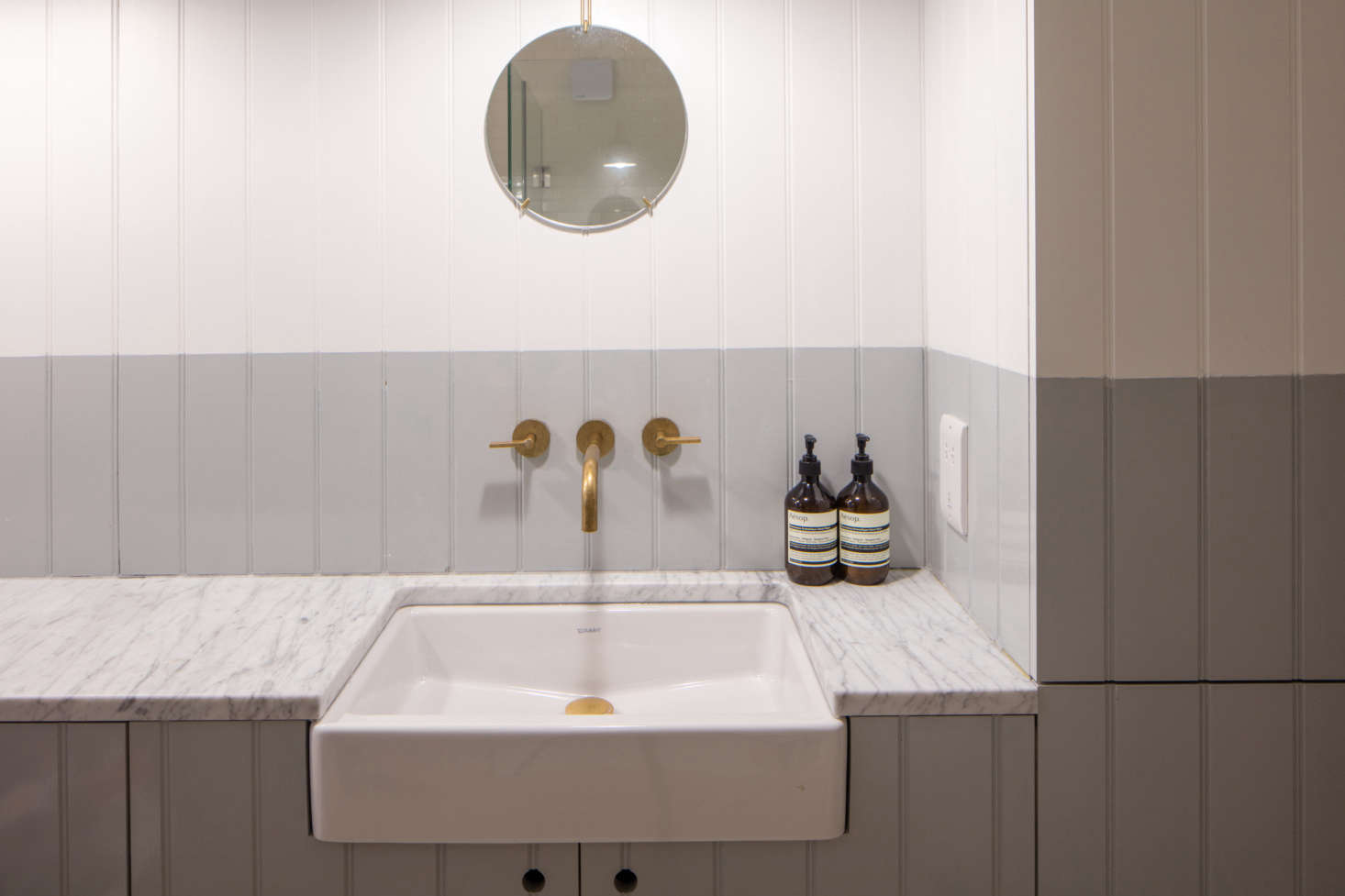A bathroom is small but luxe with a marble counter. It