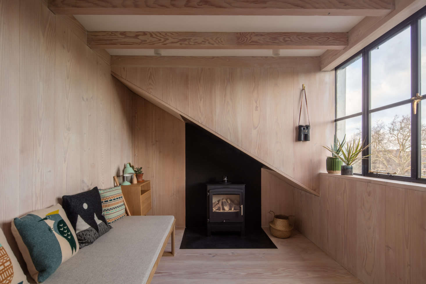 An upstairs bedroom/sitting room with another woodstove (note the black metal cladding that continues under the eaves).