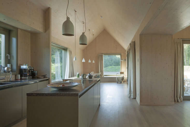 the kitchen counters are a dark brown terrazzo and the pendant lights are porce 21