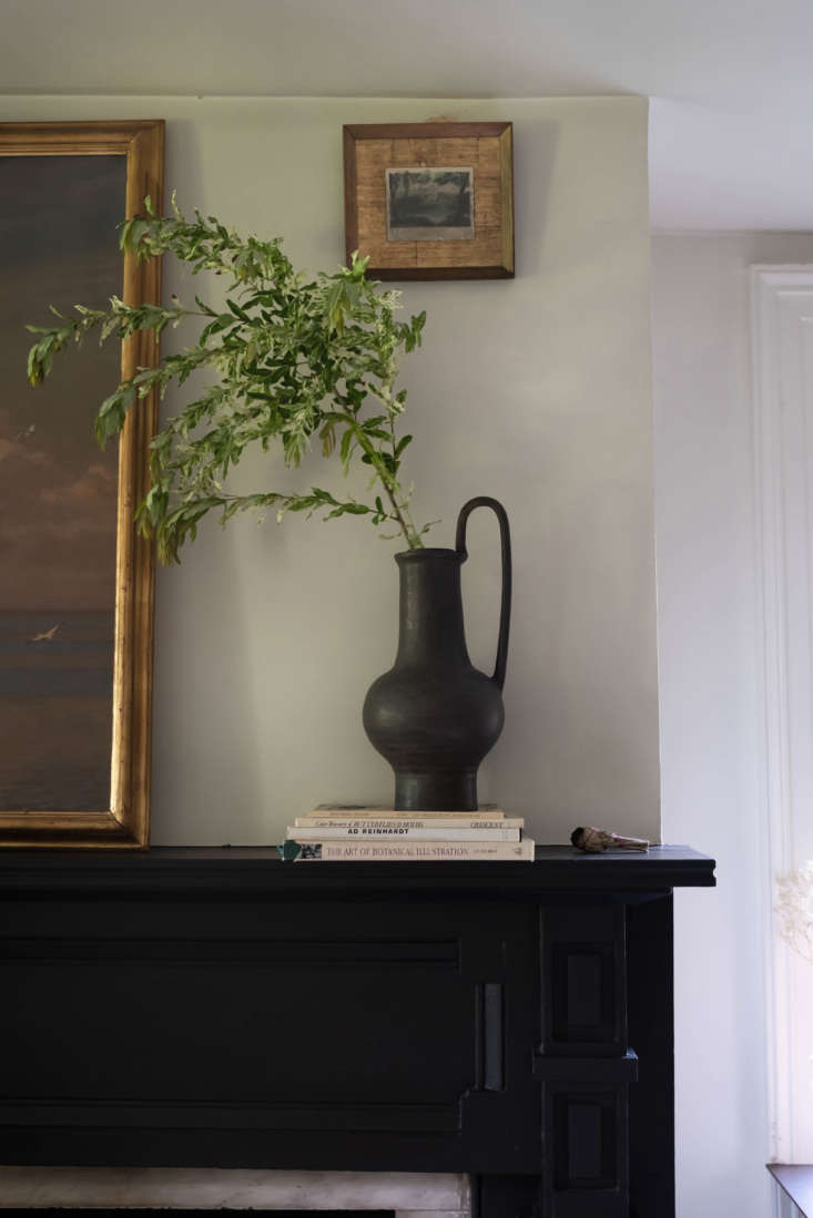 above the mantel, a small painting hung unexpectedly high creates a vignette wi 26