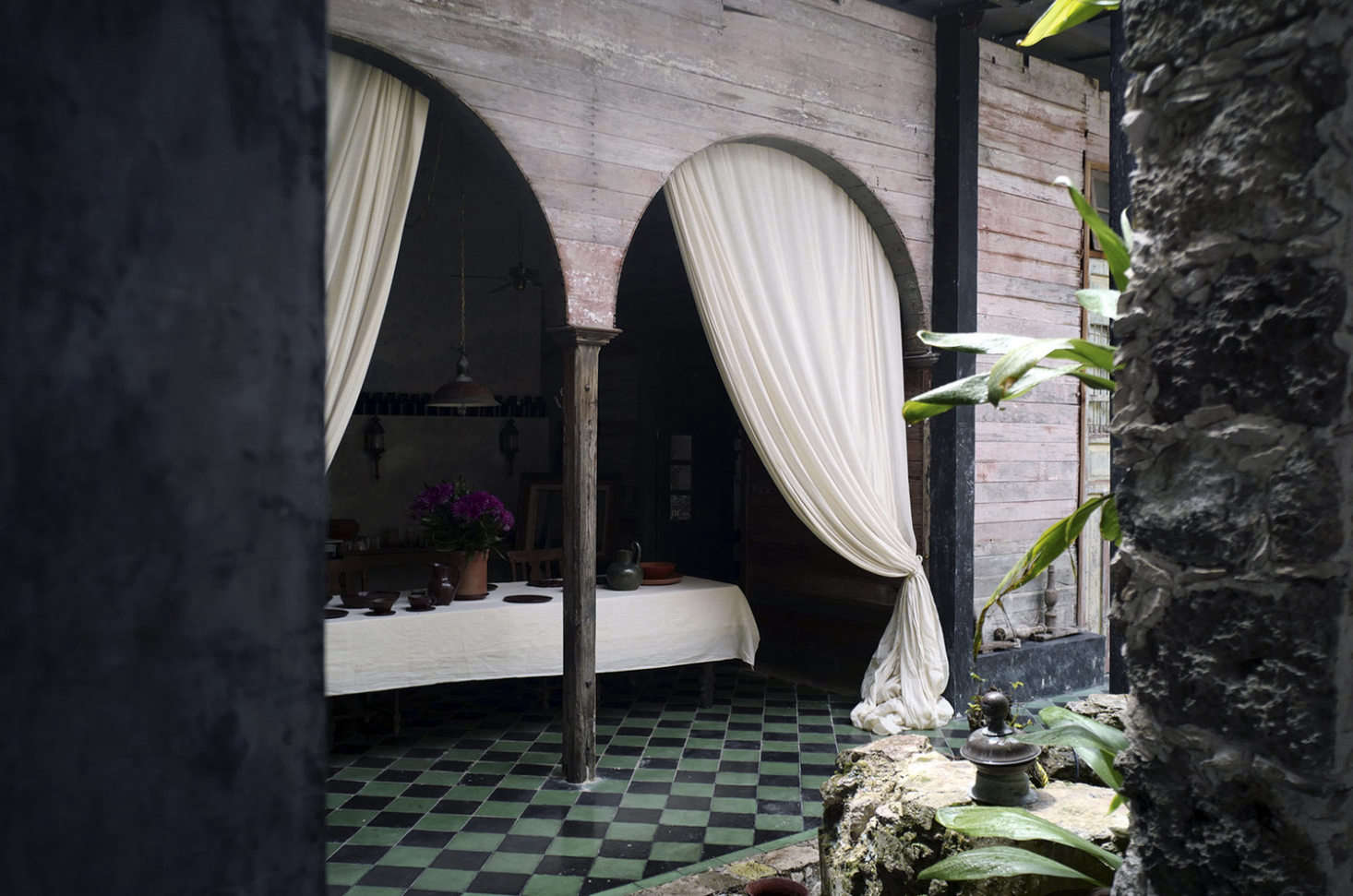 The tiled veranda, with long, sultry curtains.