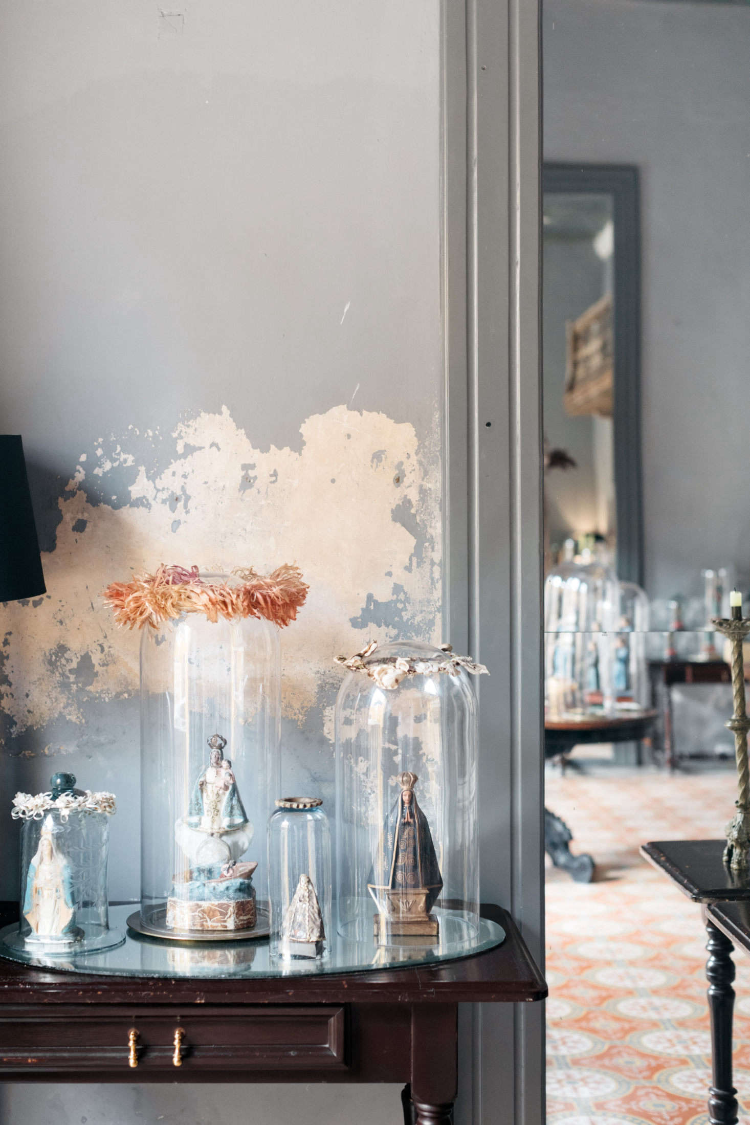 Antique figurines of saints and virgins are enshrined in glass, a nod to the city