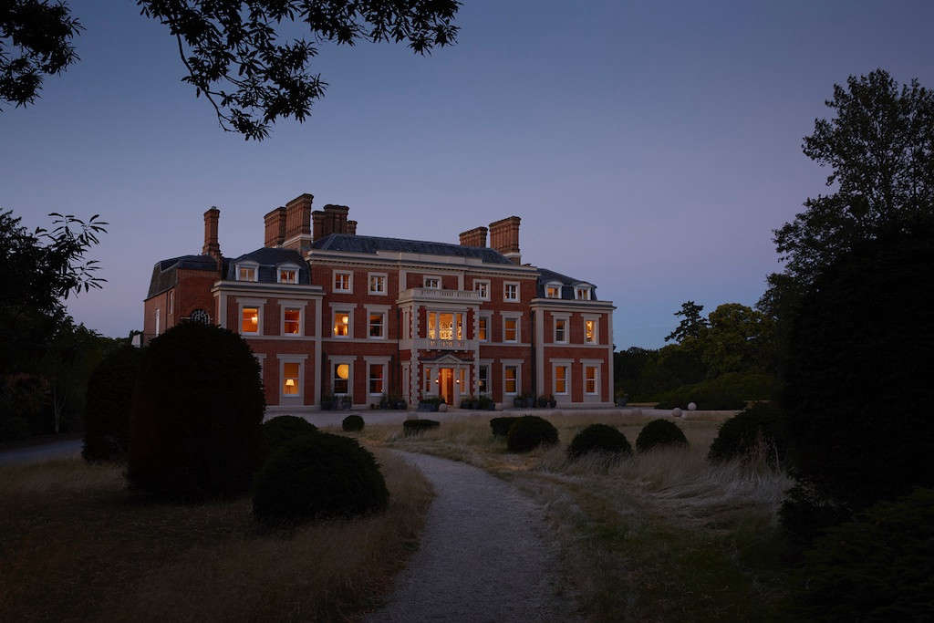 The freshly sand-blasted exterior of Heckfield Place at dusk.