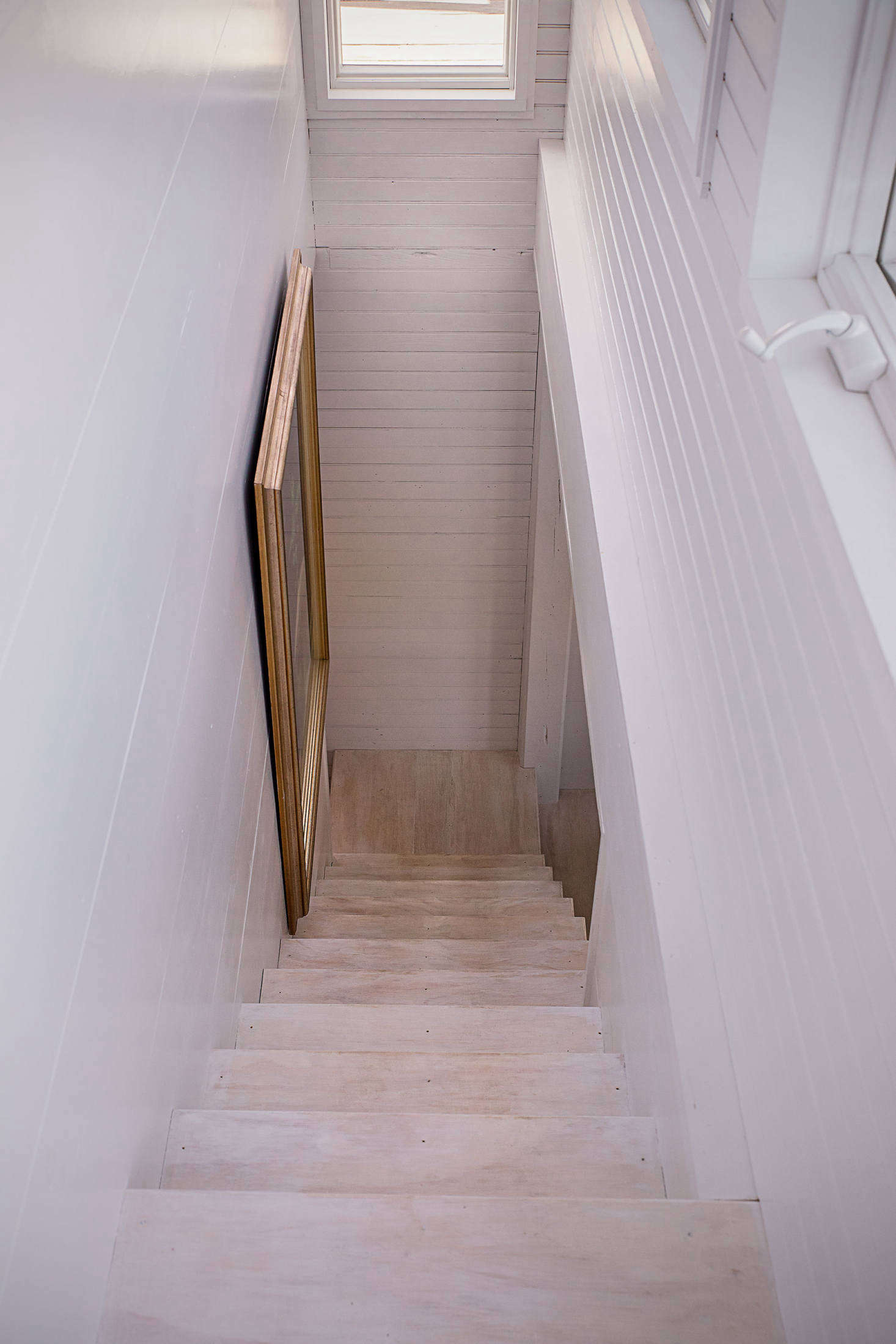 A stair leads along the back to the upstairs living area to the bedroom and shop below. Paul achieved a white-washed look in the floors with watered-down BIN.