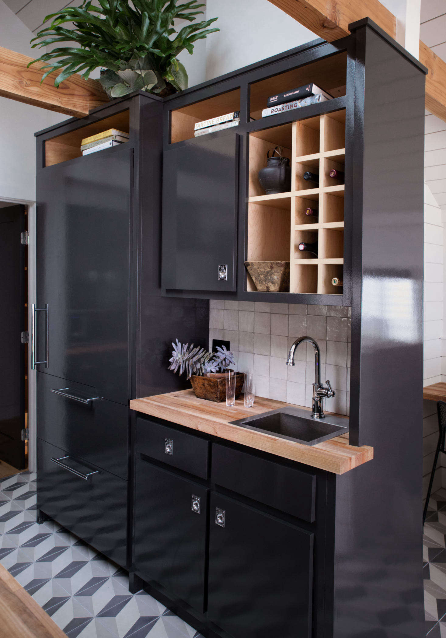 The paneled fridge and bar double as a room divider, and create a study nook and small hall leading to the bath.