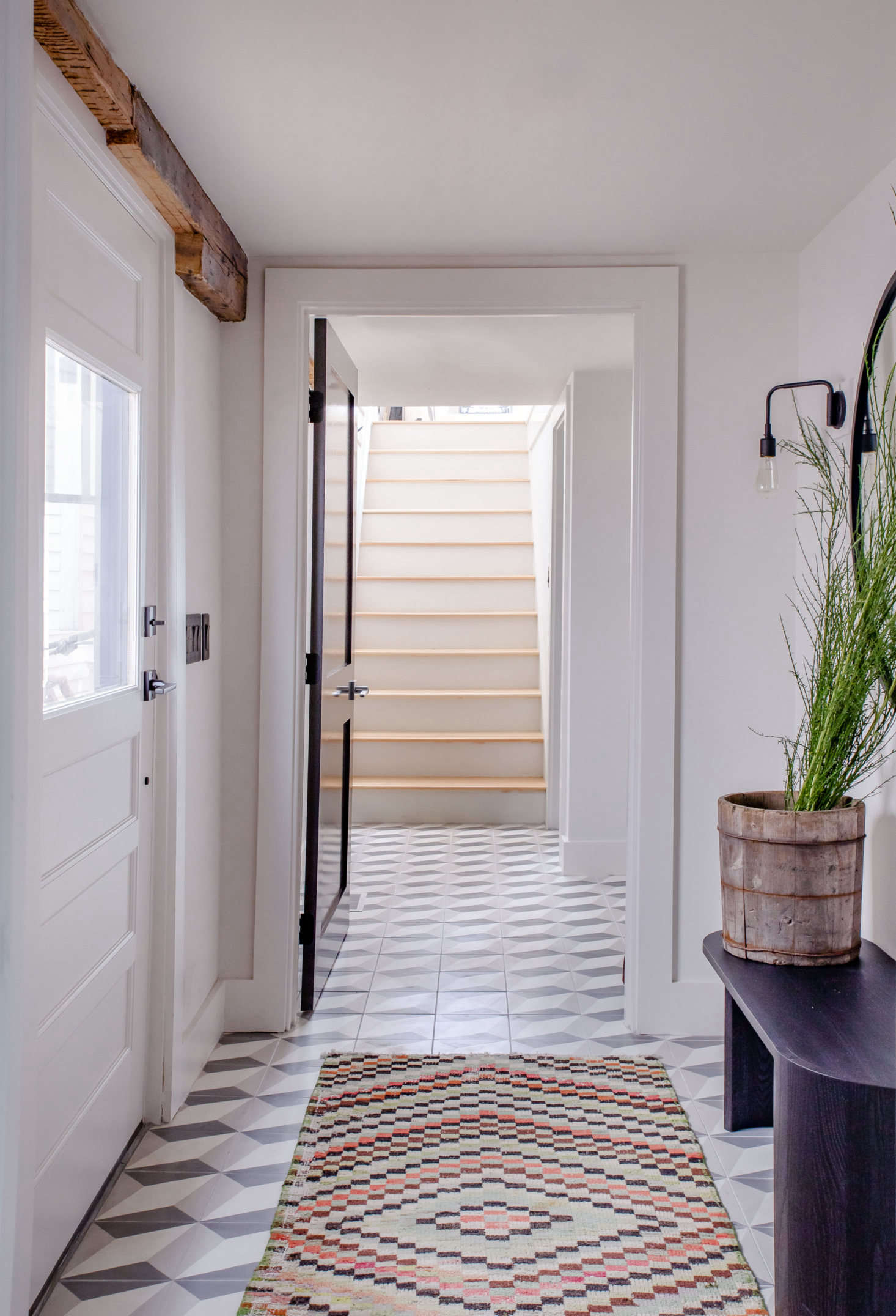 The main entry, located on the side of the property, leads to the upstairs apartment at one end and a small studio on the other.