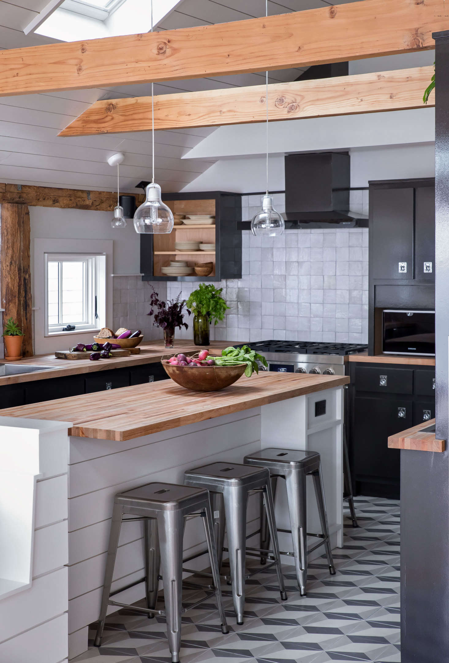On the kitchen floors and throughout the downstairs, the couple used sturdy cement tiles by Cle Tile in Diamond Twist. The black splash tiles are also by Cle: Zellige in Weathered White.