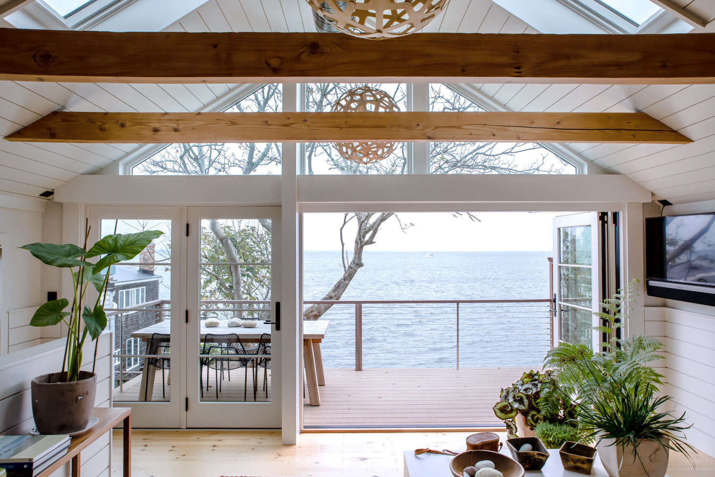 In the open, second-floor living/kitchen space, floor-to-ceiling windows and doors as well as overhead skylights flood the room with sea breezes and sunlight.