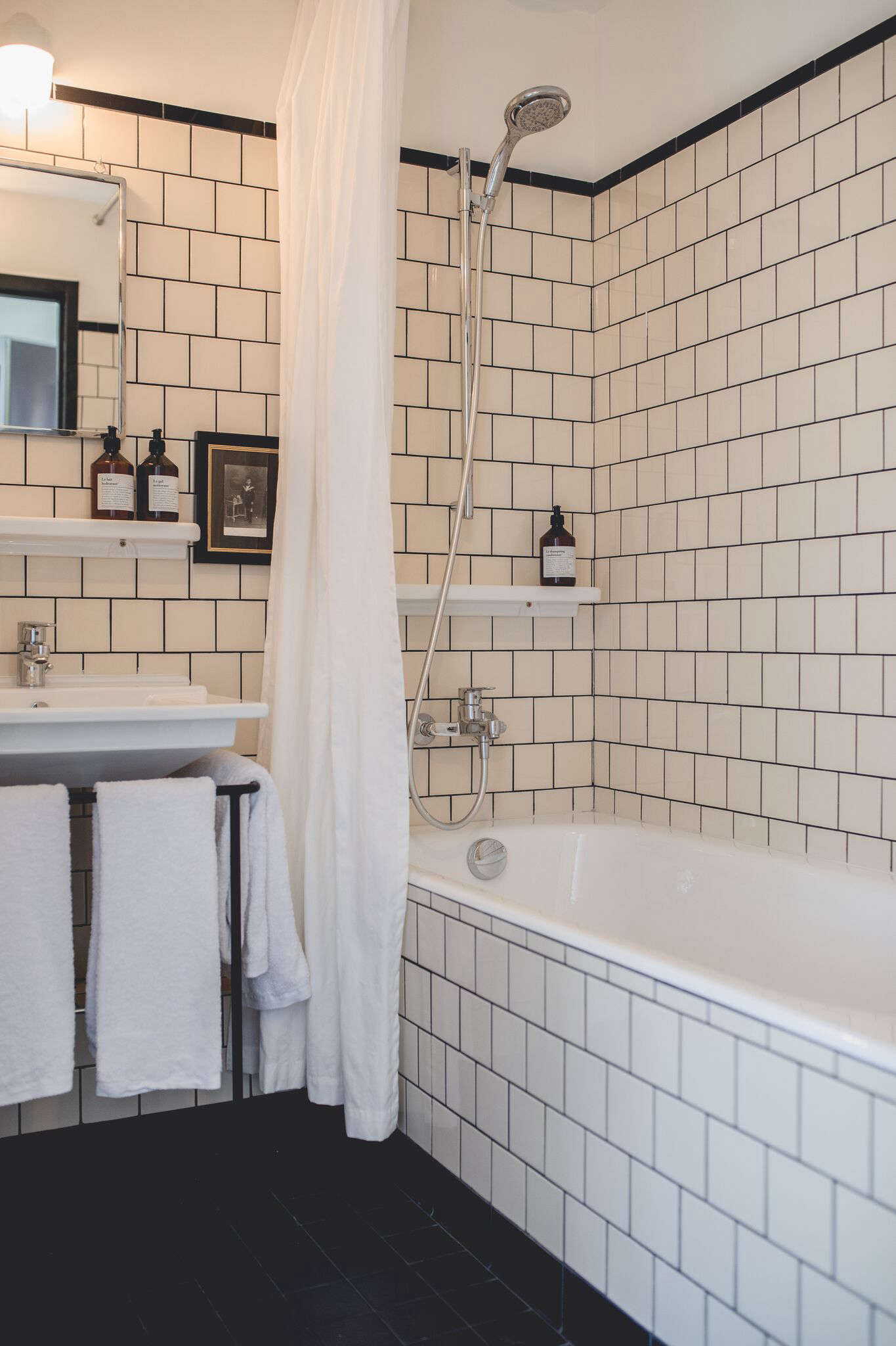 The bathrooms are stylishly detailed with classic (and inexpensive) four-by-four tiles that rise from the floor and extend across the tub. Built-in towel bars surround the sink.
