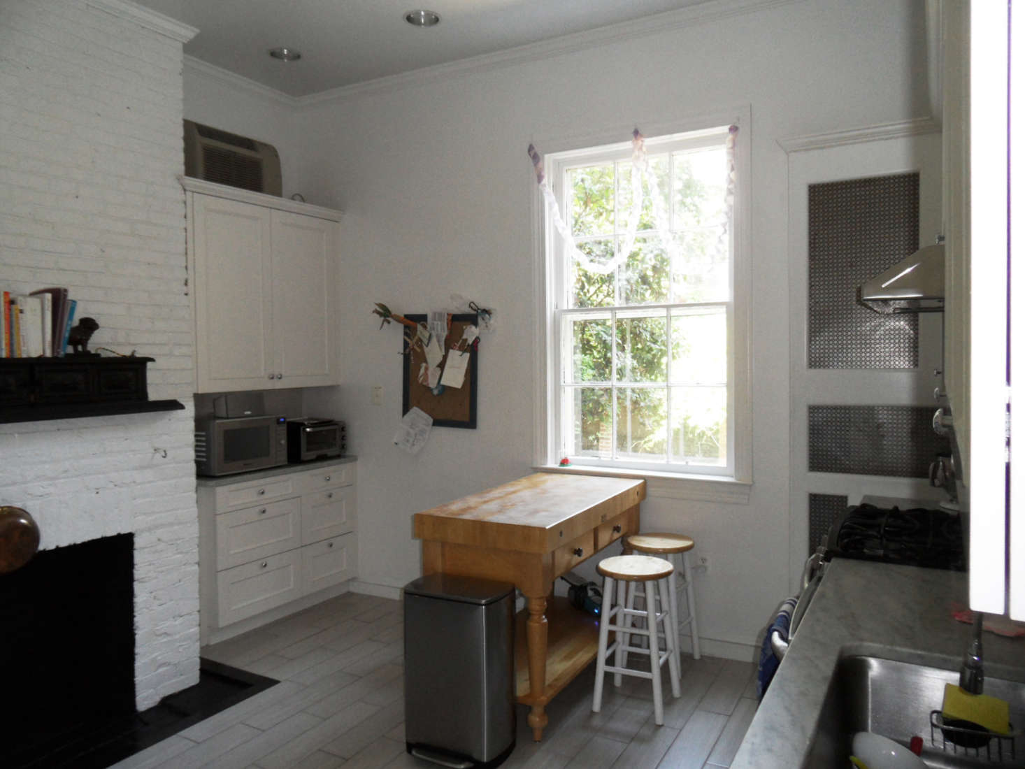 All of the appliances were on show, and the kitchen was dominated by a large brick hearth—