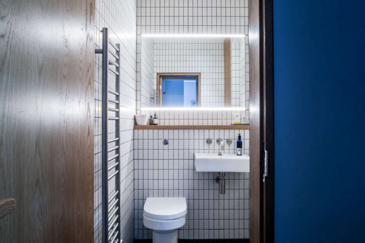 the white tiles and oak detailing reappear in the bathroom located between the  28