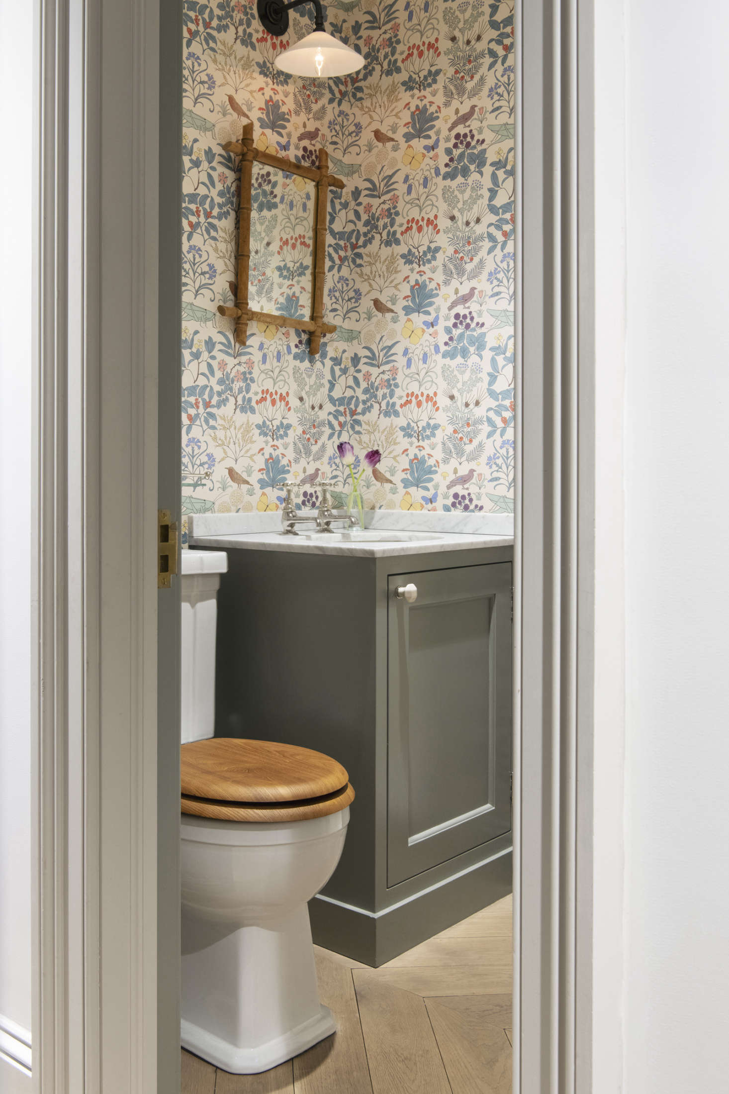 The powder room is papered in CFA Voysey
