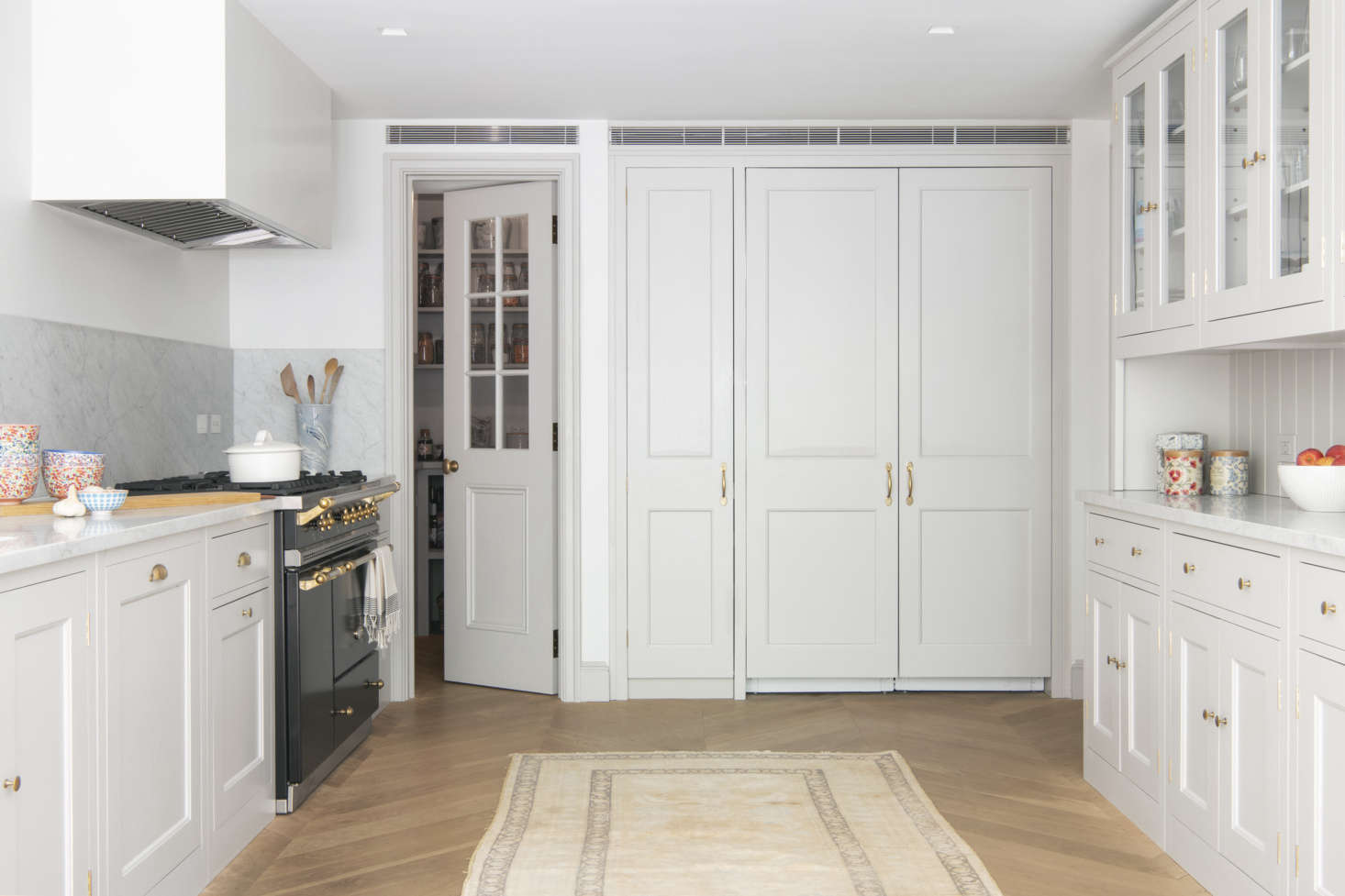 An integrated Sub Zero double-doored fridge in the back of the room is flanked by a pantry on one side and the mudroom on the other.