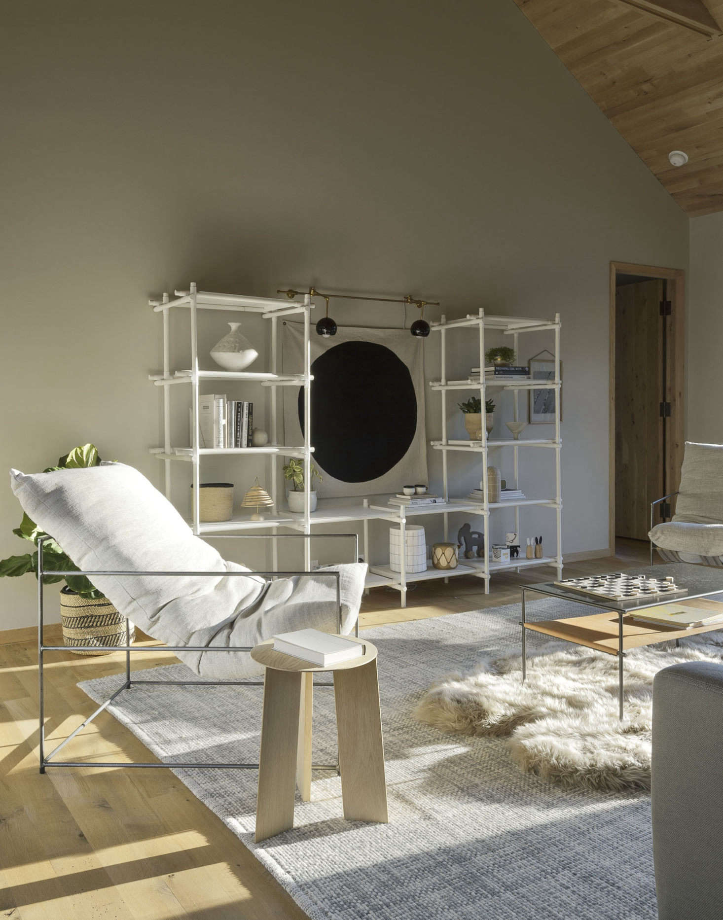 The second-floor den is outfitted with custom-upholstered Sierra chairs by Crofthouse in LA (the fabric is from StudioFour) and Stick System shelving from Menu.