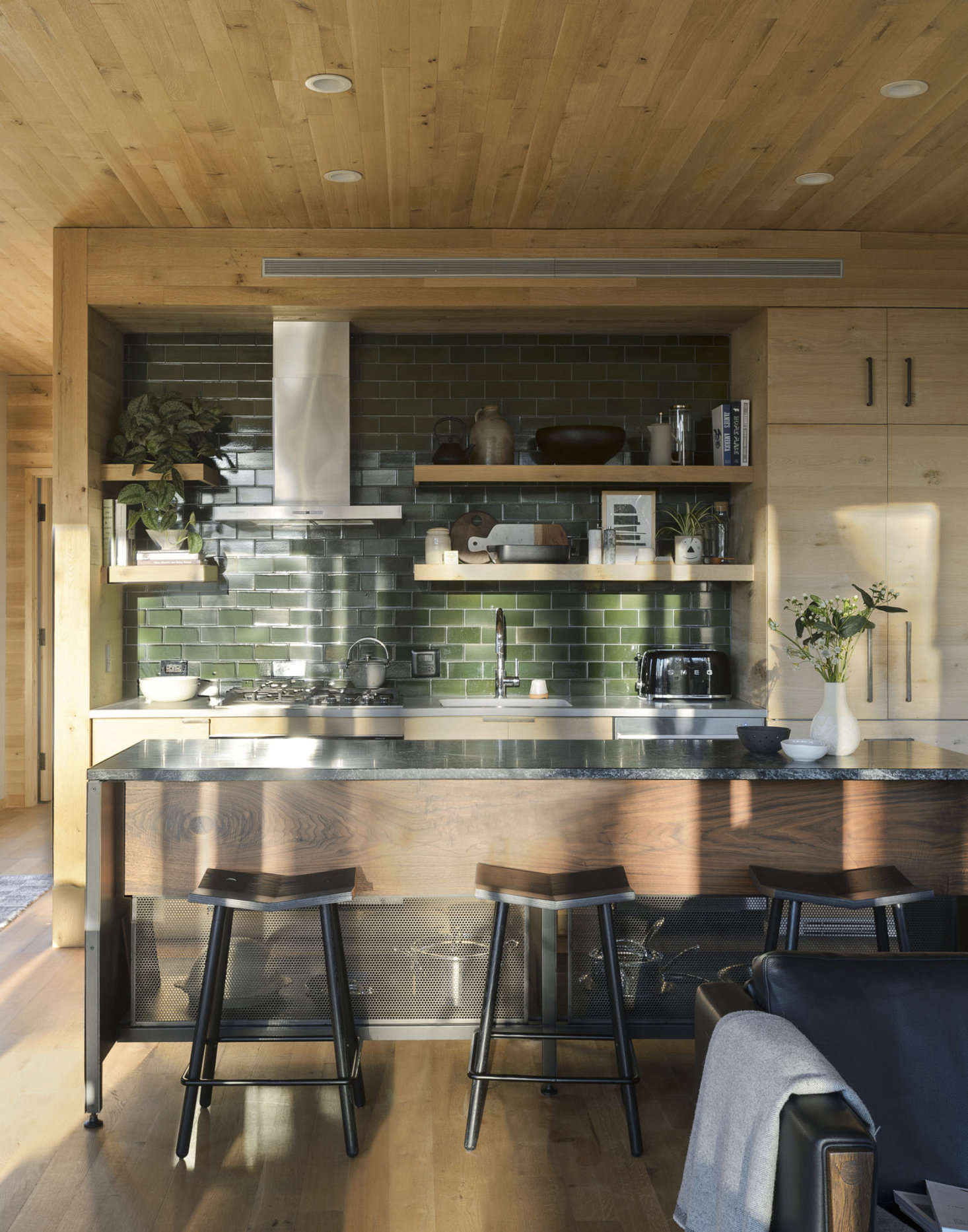 Tucked into the walnut kitchen island are Mitre stools from Souda. The appliances are by Fisher & Paykel.
