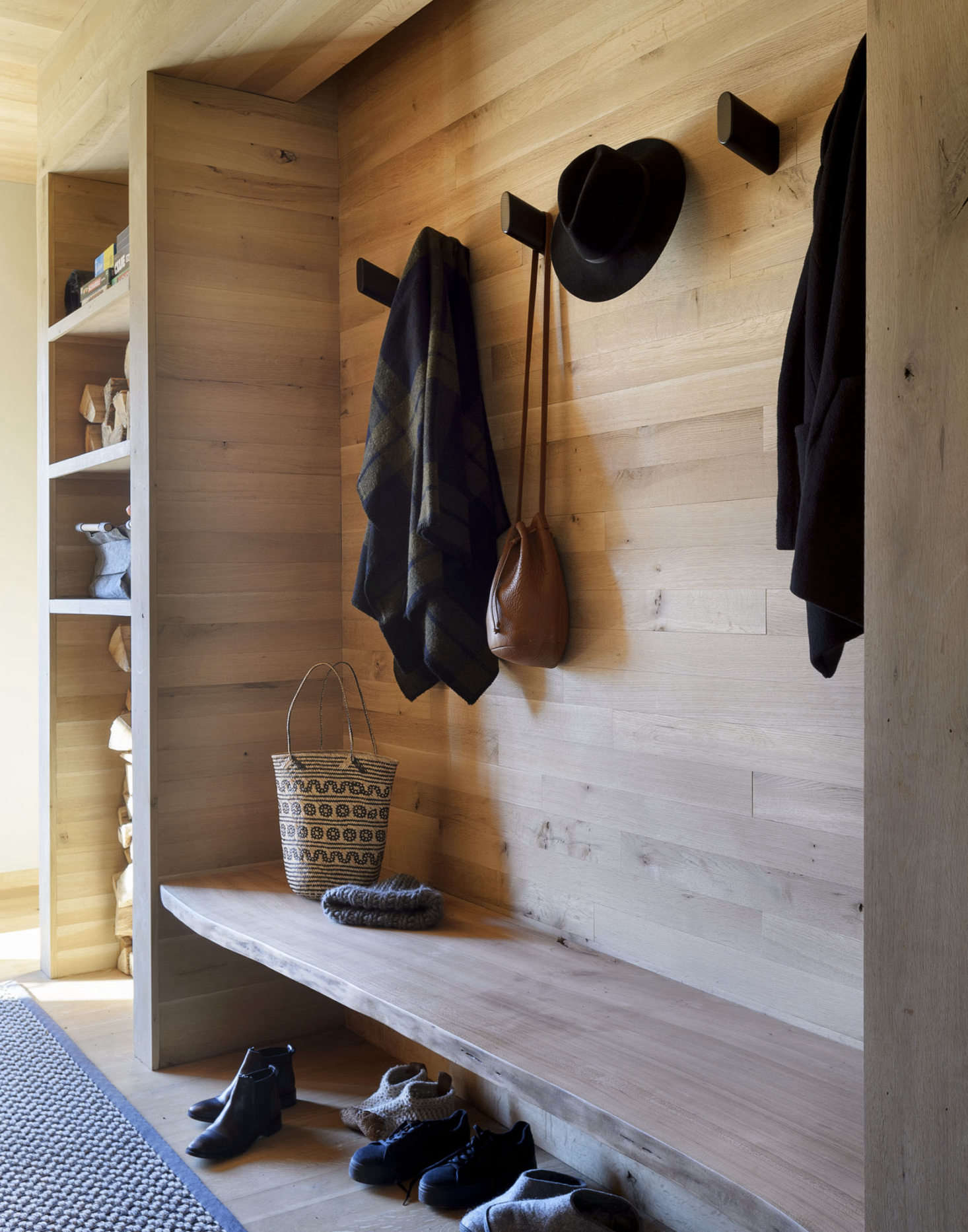 A built-in bench in the entry. The Wook wall hooks are by Blu Dot.