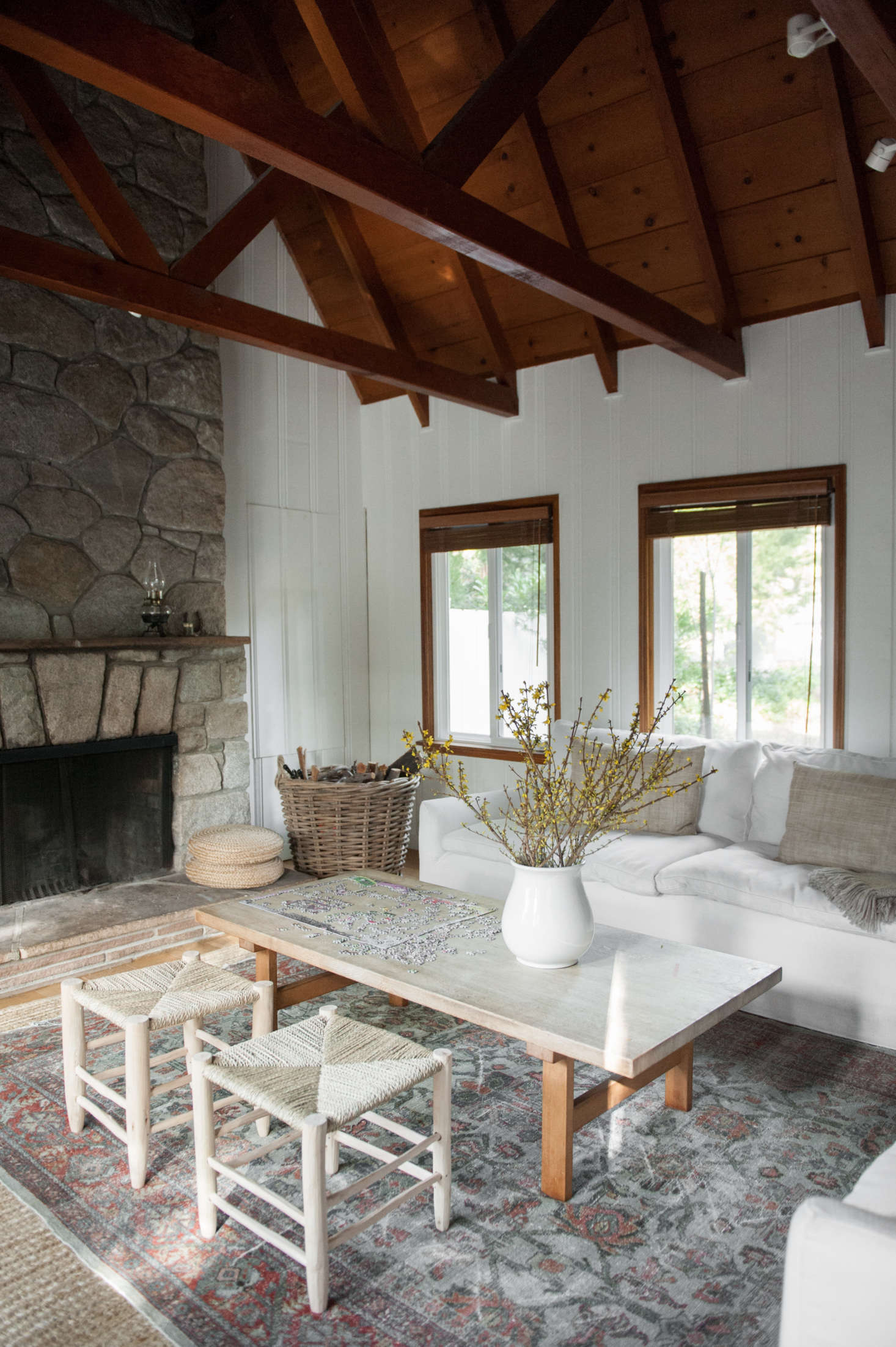 The stone fireplace is original and gets put to use year-round. Lauren placed a patterned carpet over a sisal base: 