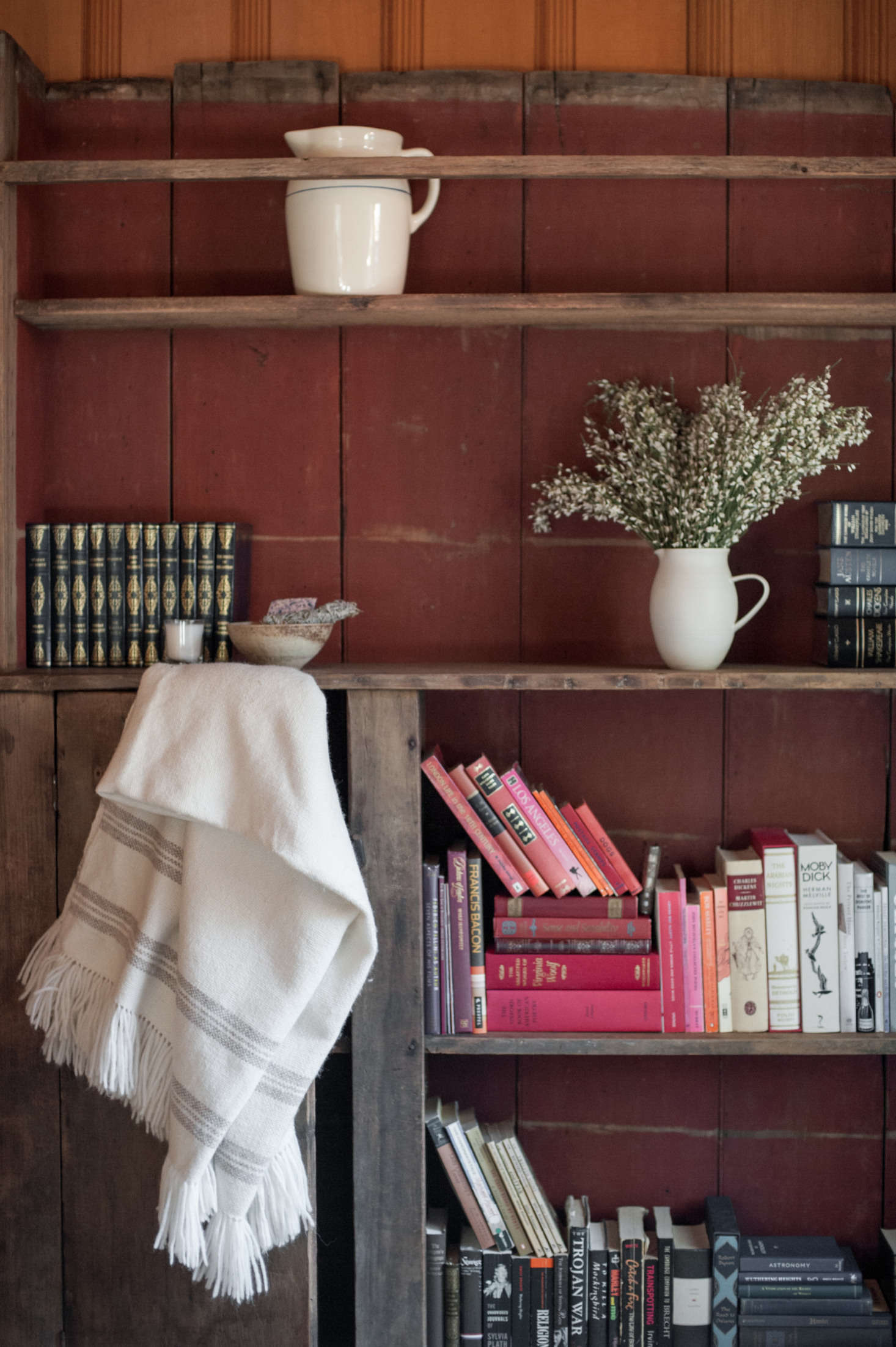In the guest room, a painted bookcase found at Brenda Antin Antiques holds Leanne