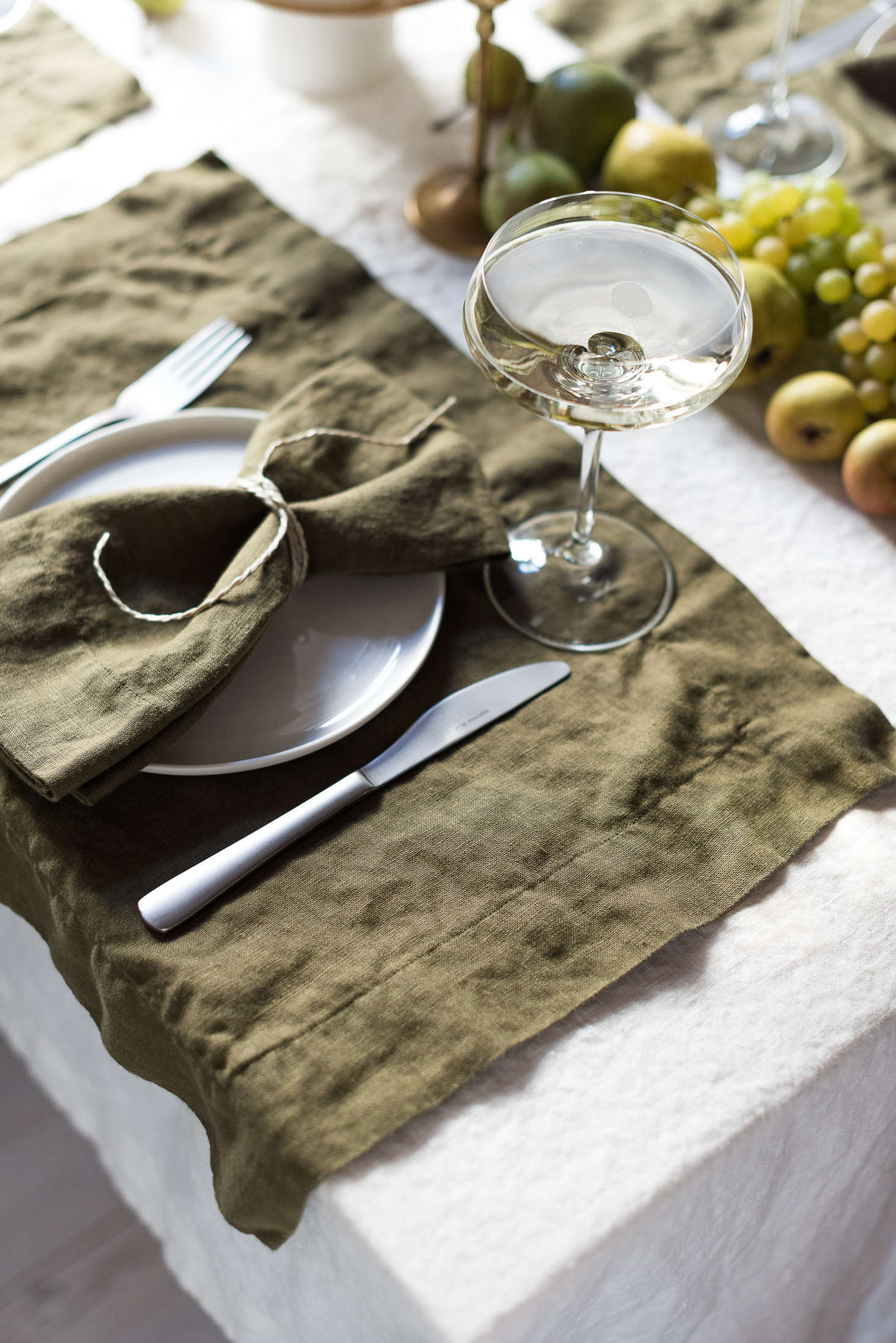 A detail of the place setting, with placemats left to overhang the table just slightly.