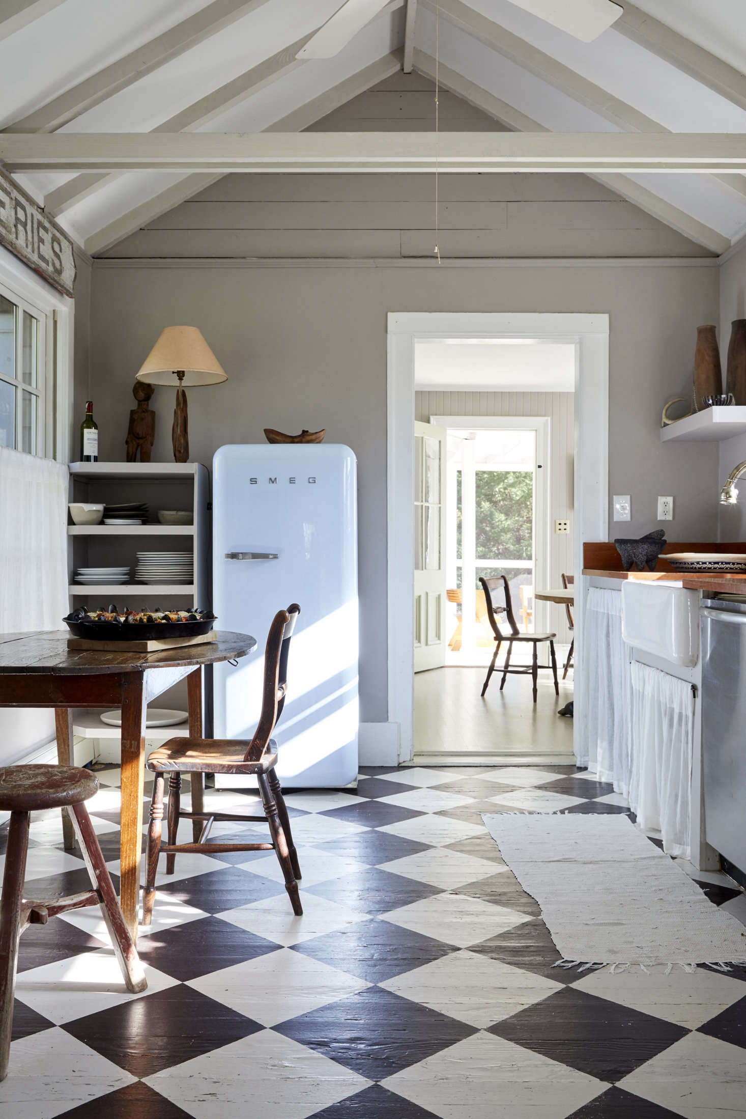 White textiles, wood accents, and a neutral wall paint allow the checkerboard floor to really shine.